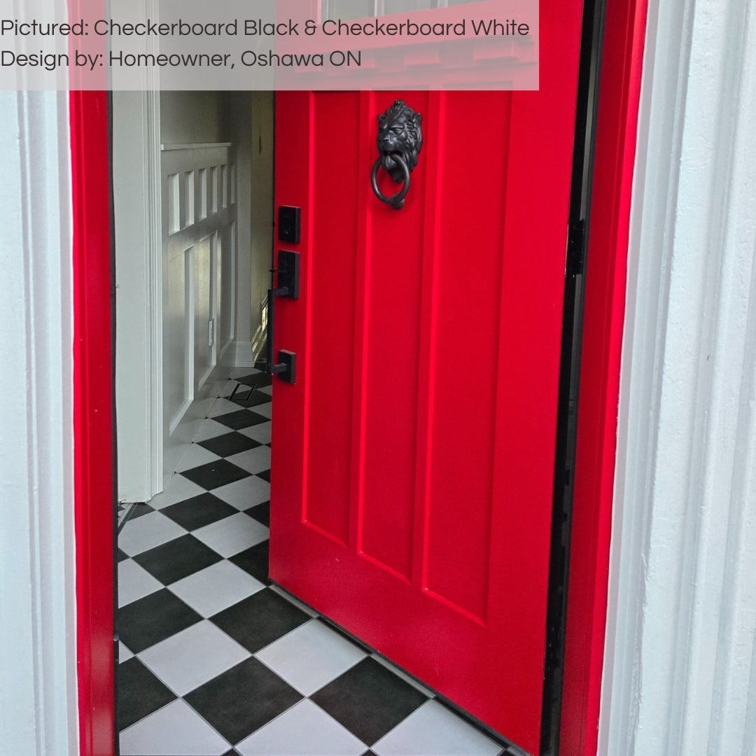 A captivating entry way featuring checkerboard black and white 8x8 matte tiles installed in a diamond checker pattern with white walls and a red exterior door. 