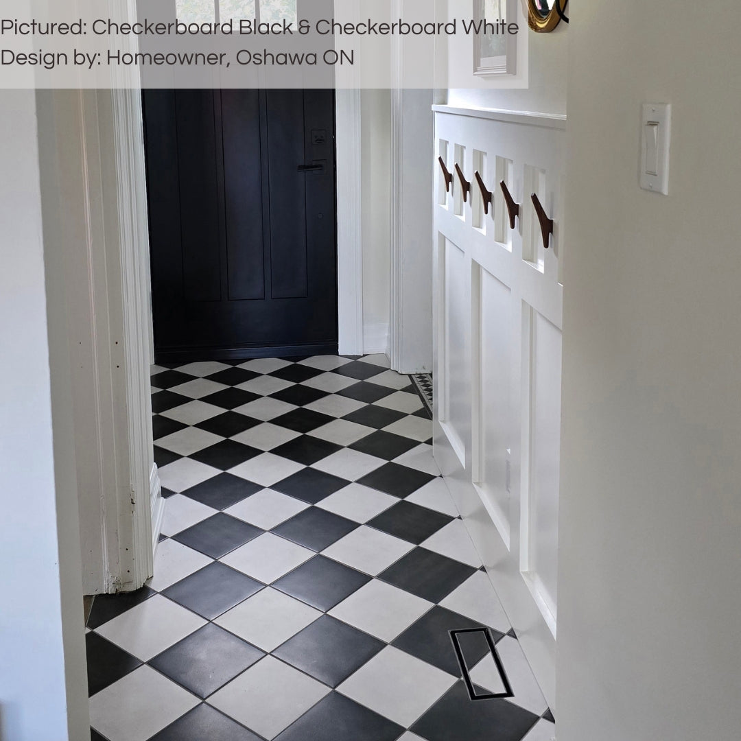 A timeless entry way featuring checkerboard black and white 8x8 matte tiles installed in a diamond checker pattern with white walls and a black interior door. 