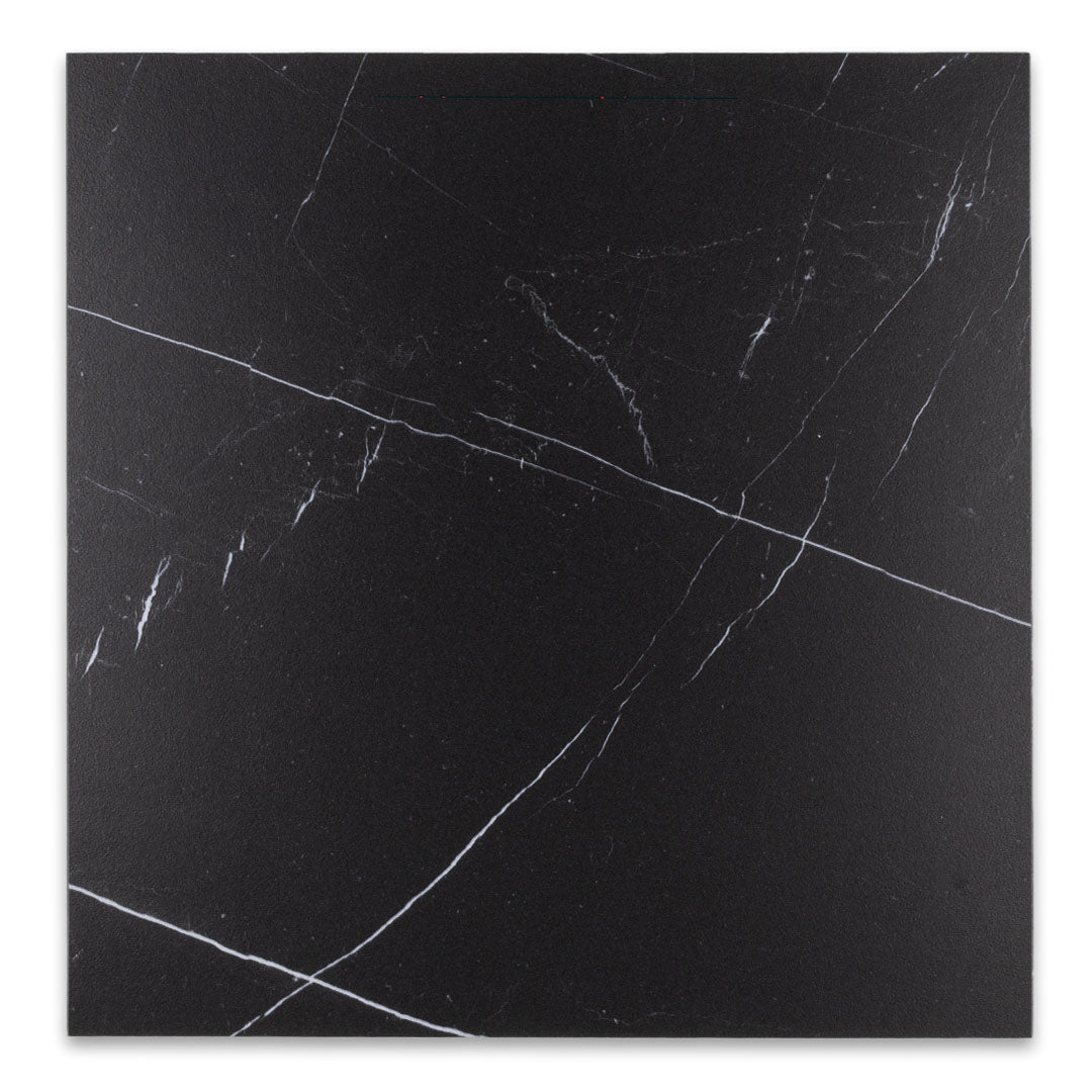 Maison Noir is a black 12x12 matte marble look black tile. perfect for checkerboard applications. his images shows the single tile on it's own with a fine white veining pattern across the rich black tile. 