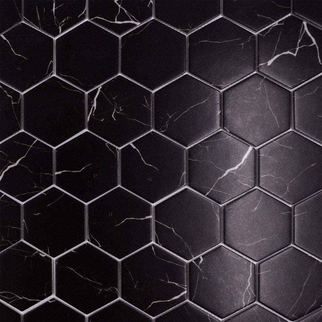 Close up of black marquina marble look 3 inch hexagon mosaic sheet tiles to show the deep colour, marble veining and finish. 
