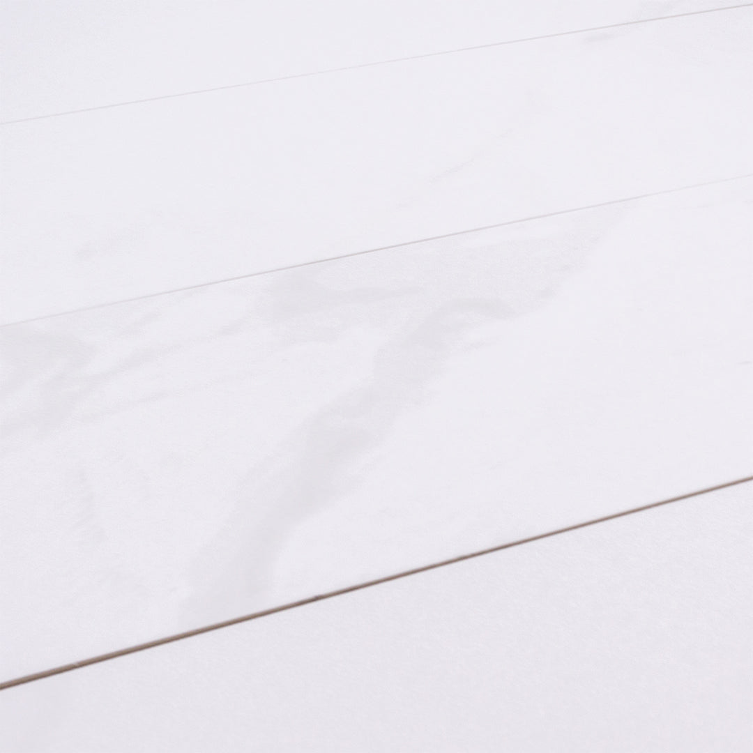 angled close up view of four 5x16 white stone look tiles to highlight the very soft marble pattern. 