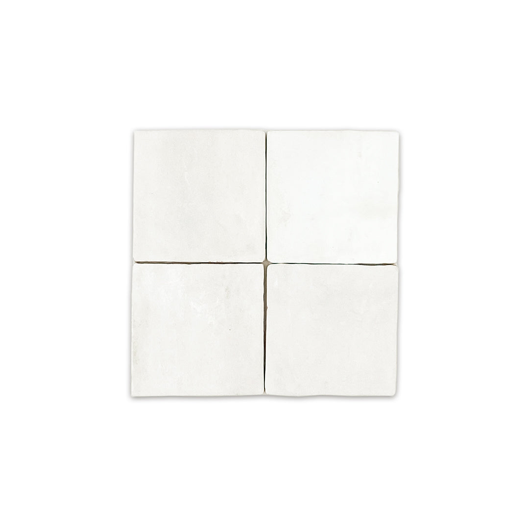A group of four 4x4 satin zellige tiles named white. they have a handmade look, textured imperfect edges and a subtle colour variation