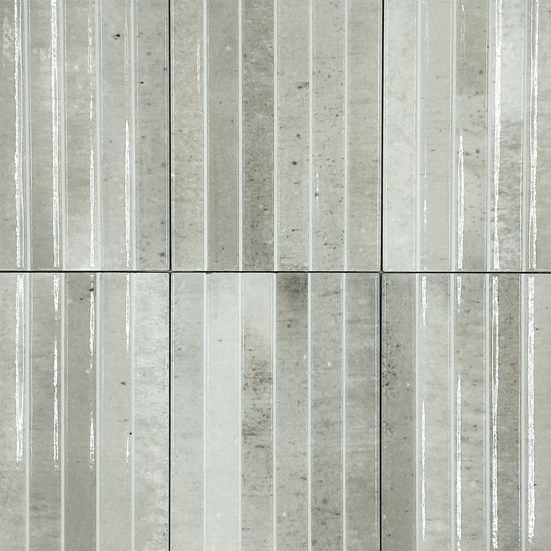 Ariel view of a group of 5x10 panel tiles in glossy grey, the tile has a 3D linear faux grout line fluted kitkat look and colour variation. 