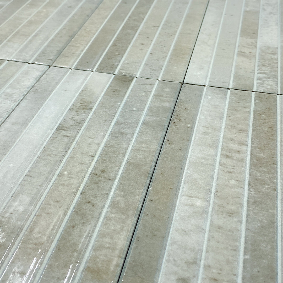 Ariel view of a group of 5x10 panel tiles in glossy grey, the tile has a 3D linear faux grout line kitkat look and colour variation. 