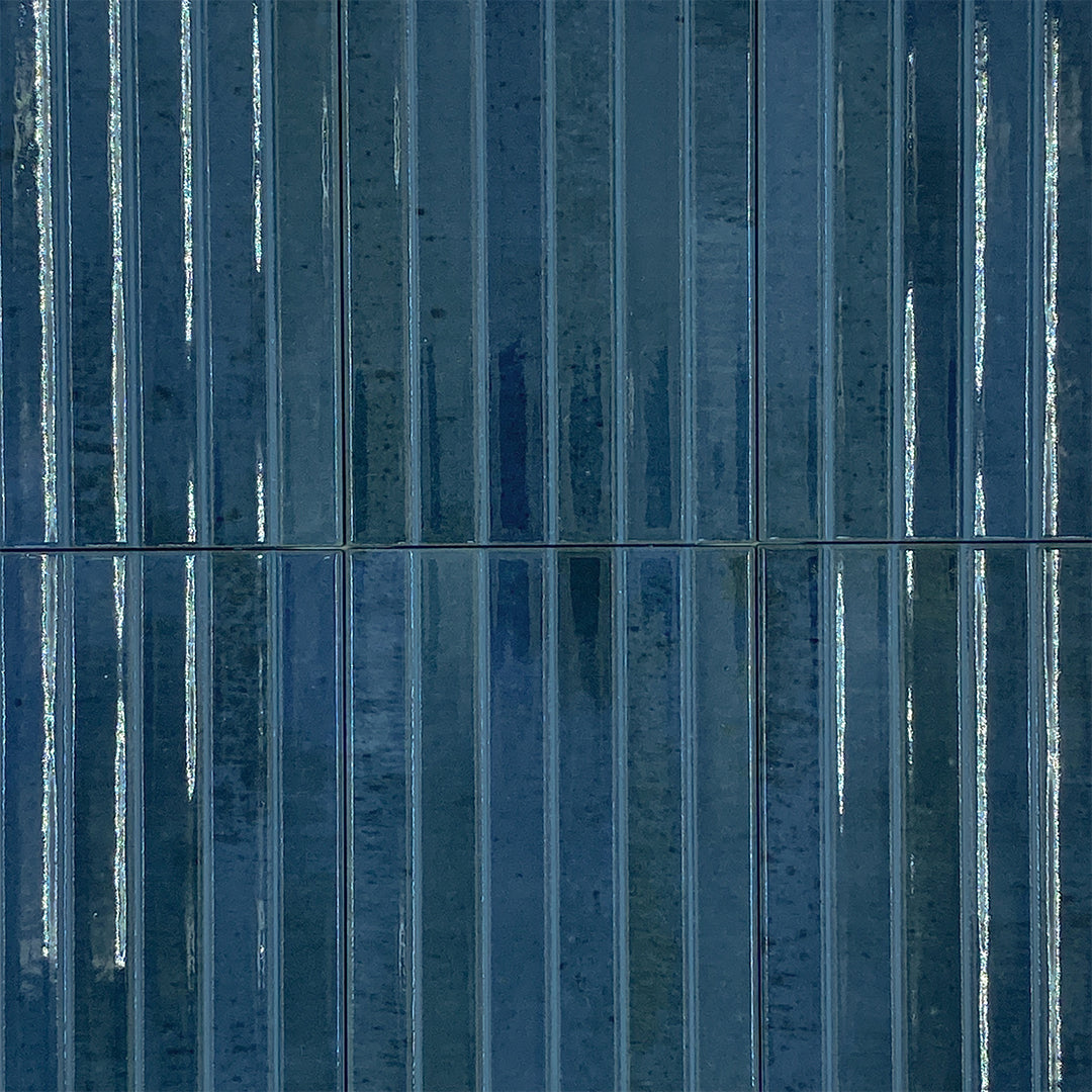 Ariel view of a group of 5x10 panel tiles in glossy navy blue, the tile has a 3D linear faux grout line kitkat look. 