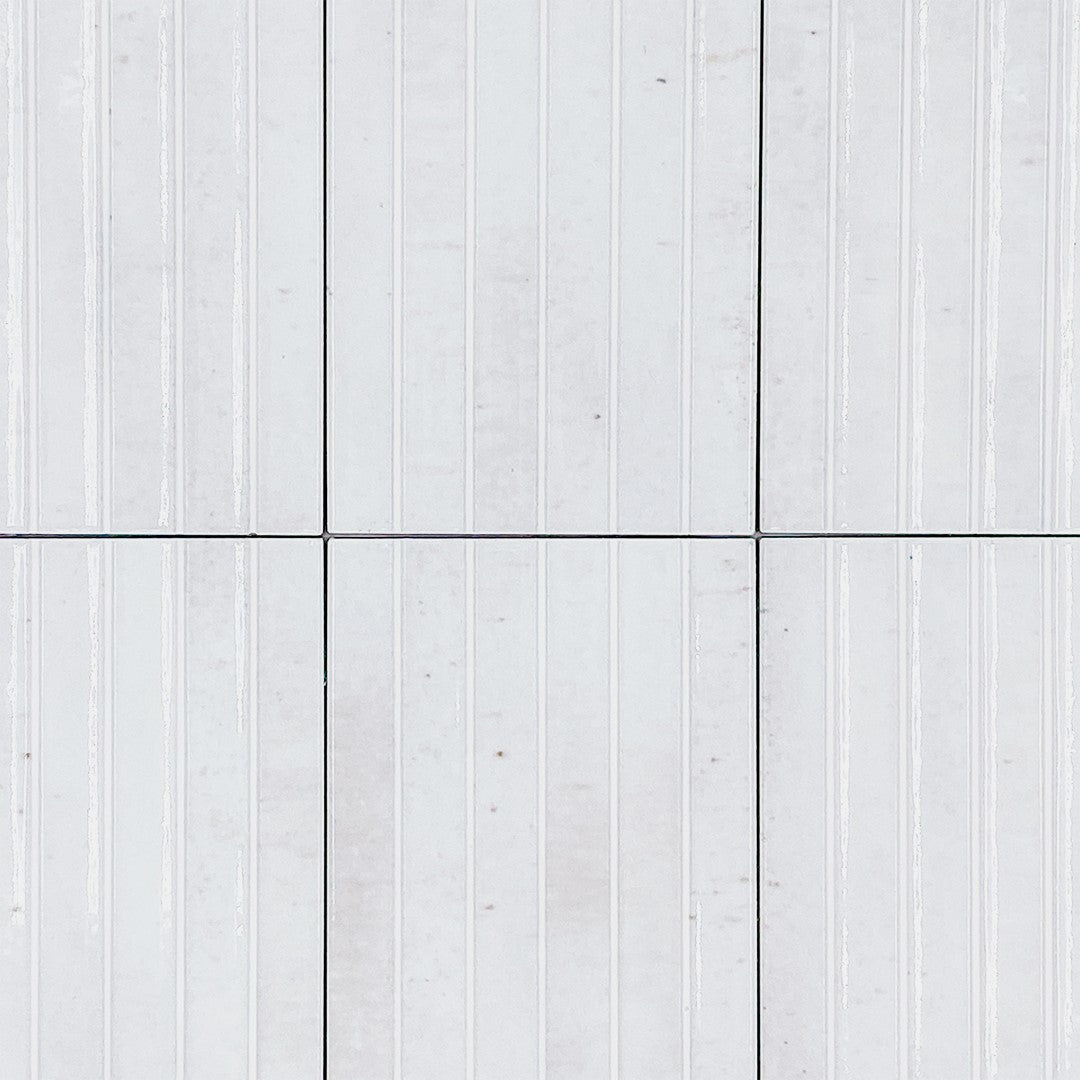 Ariel view of a group of 5x10 panel tiles in glossy milk white, the tile has a 3D linear faux grout line fluted kitkat look and colour variation. 