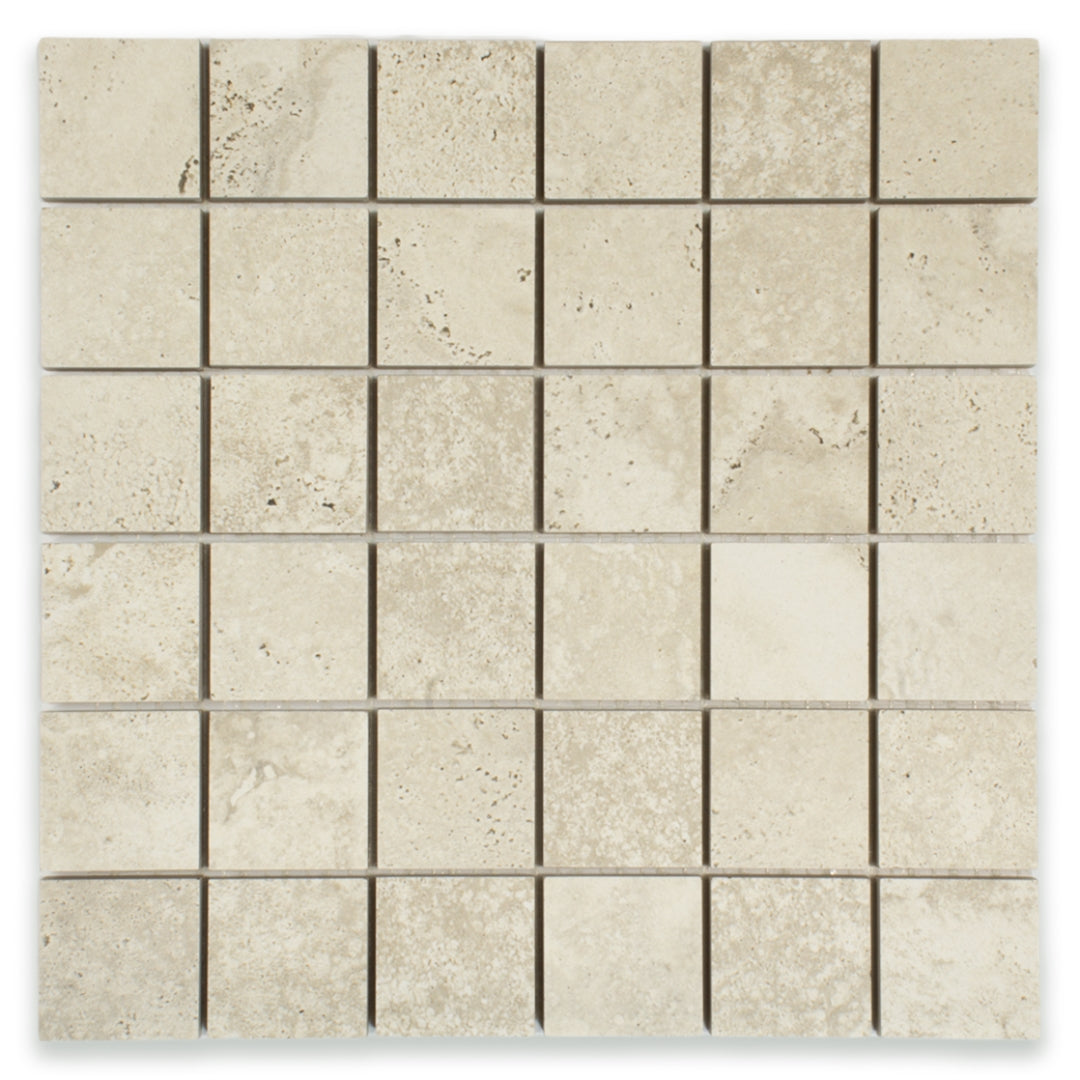 Ariel close up of a 2x2 square mosaic tile that resembles travertine stone in griege. 