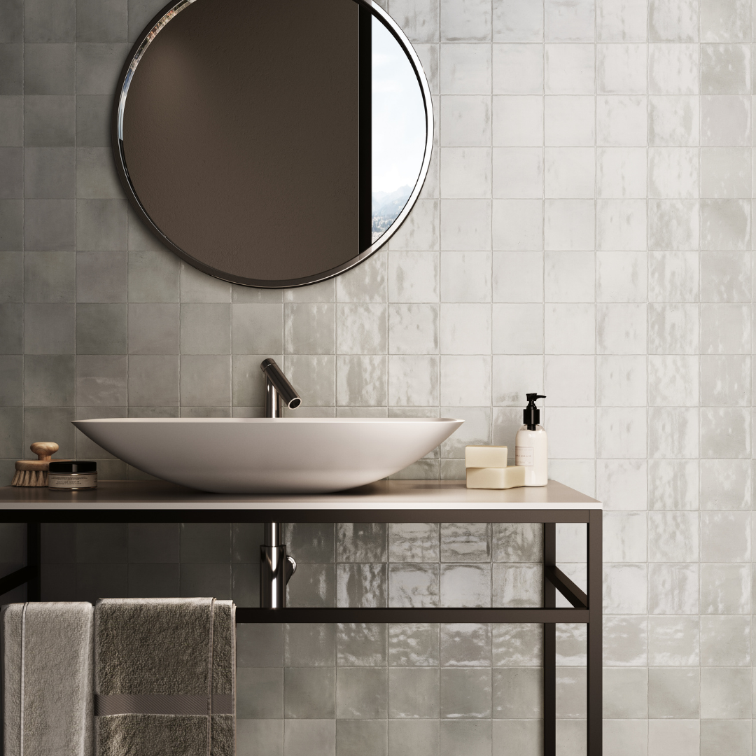 A modern poweder room installation of glossy 4x4 textured grey tiles on the walls showing the colour variation and finish. 