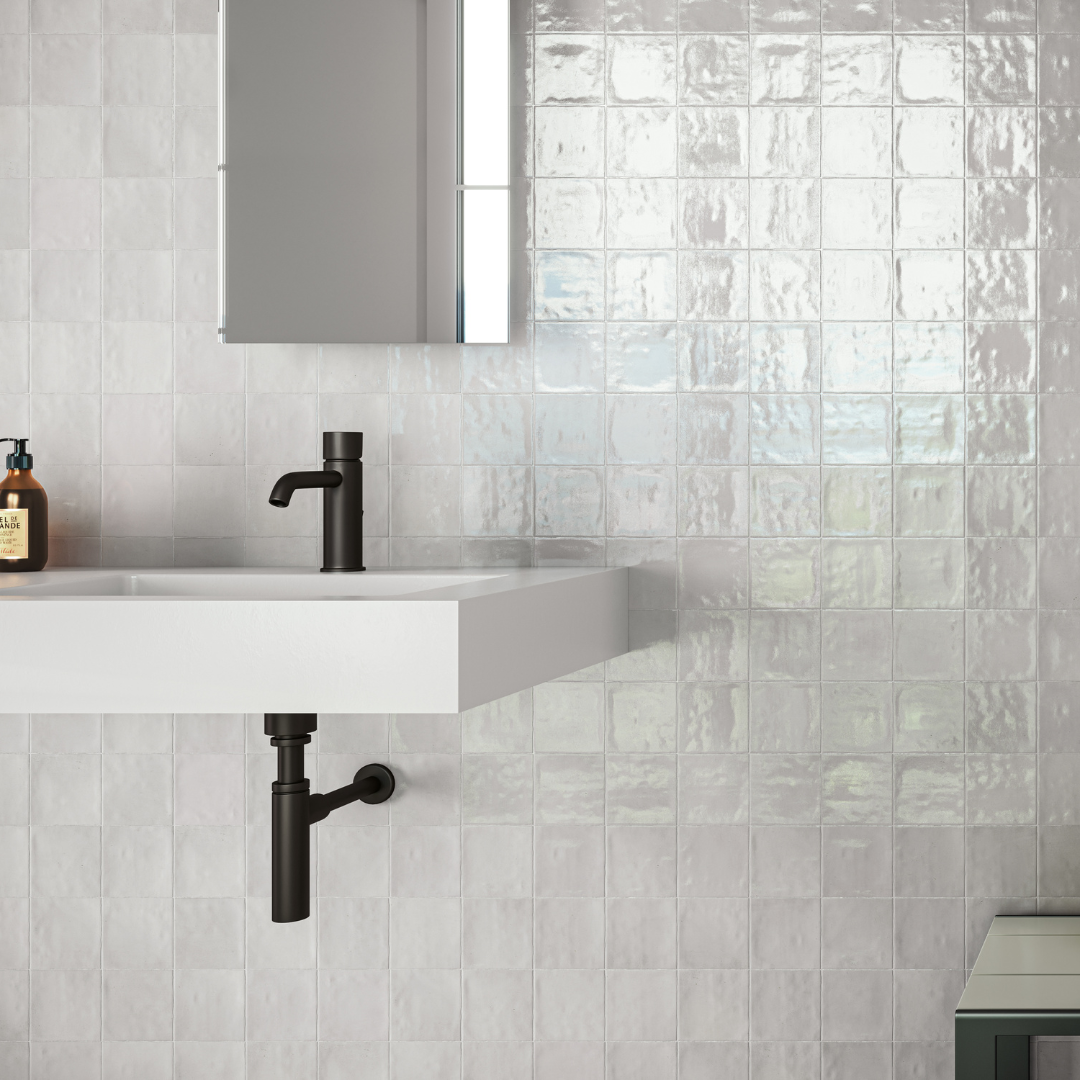 A modern poweder room installation of glossy 4x4 textured grey tiles on the walls. 