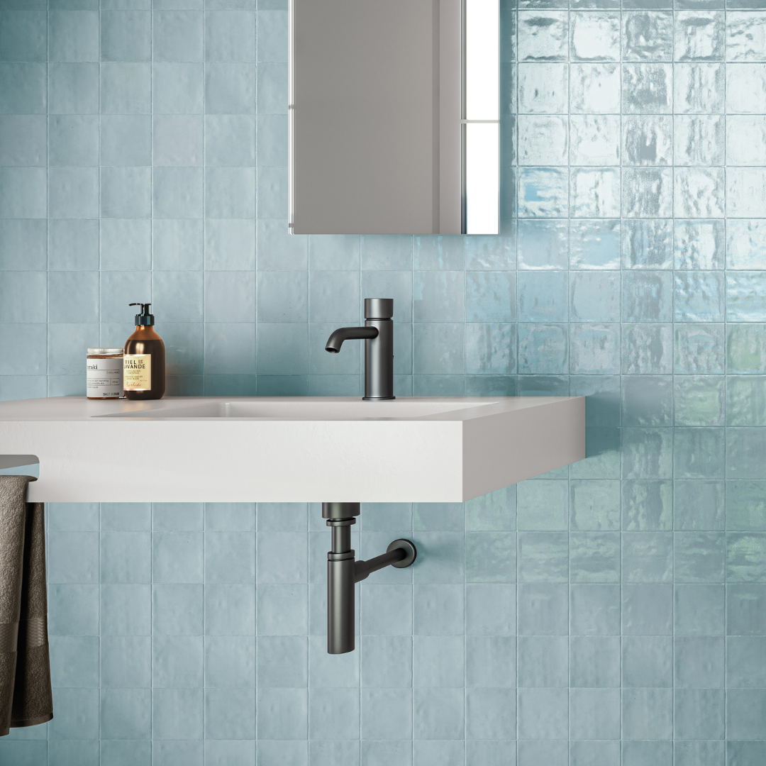 A modern powder room with light denim blue 4x4 glossy textured wall tiles. 
