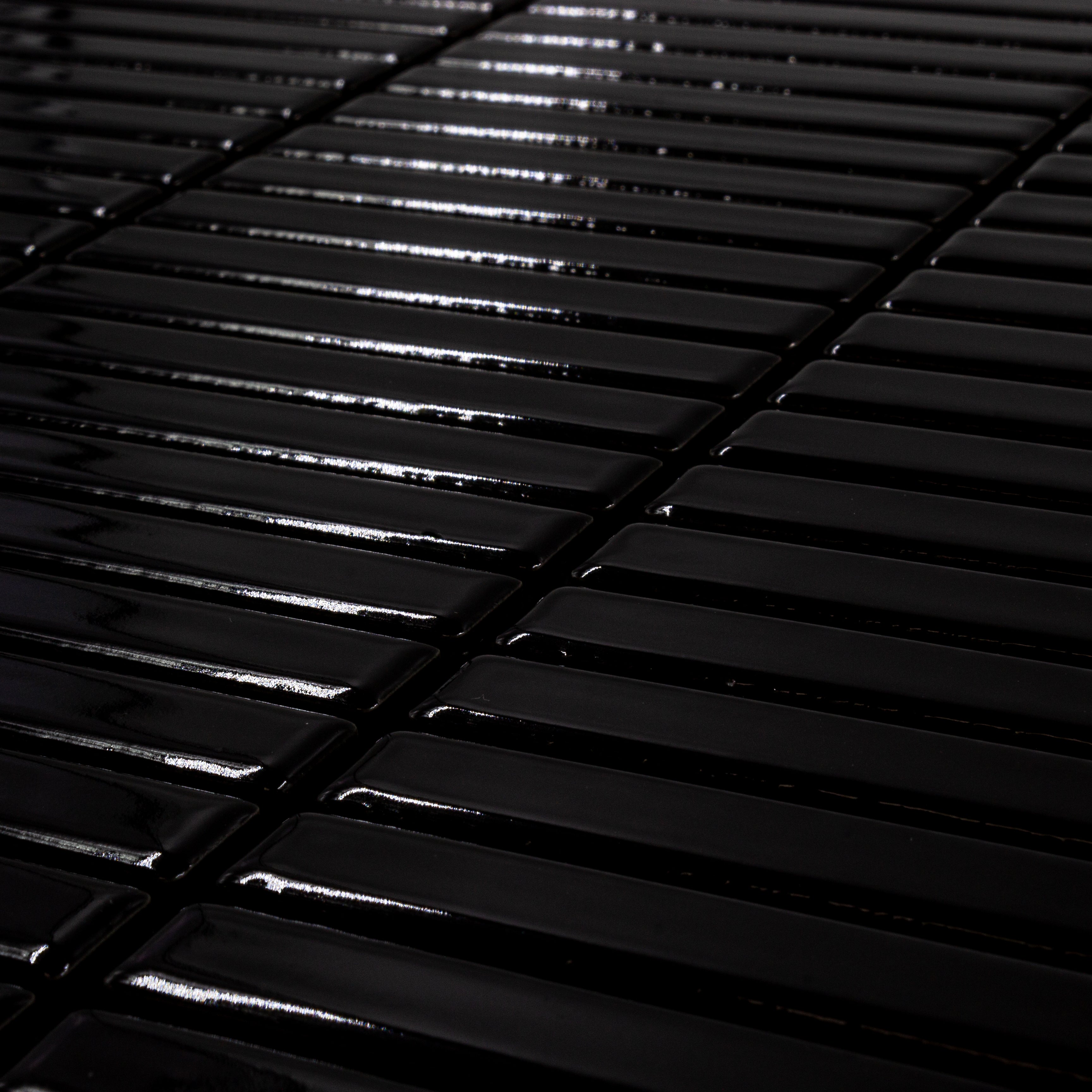 Angled close up view of a single sheet of mini kitkat stacked mosaic tiles in rich black glossy. The sizing is 3/8' x 3-5/8" per tile, 10.5" X 12" per sheet