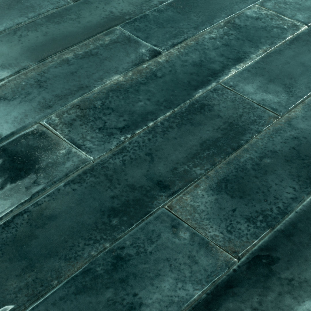 Angled close up of 2x9 green glossy tiles in a brick layout
