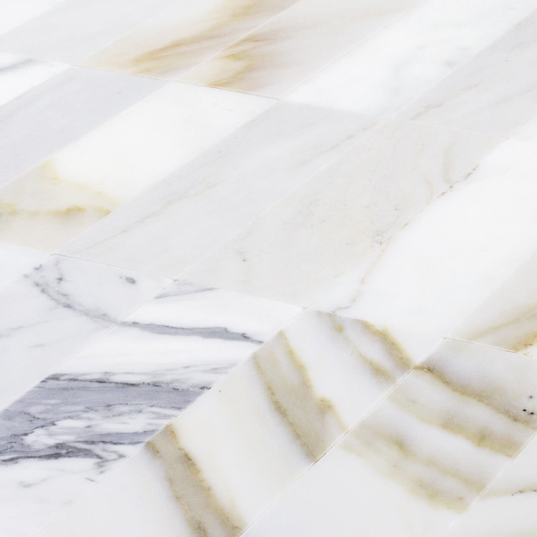 a close up of a group of matte calacatta 2x6.5 subway tiles
