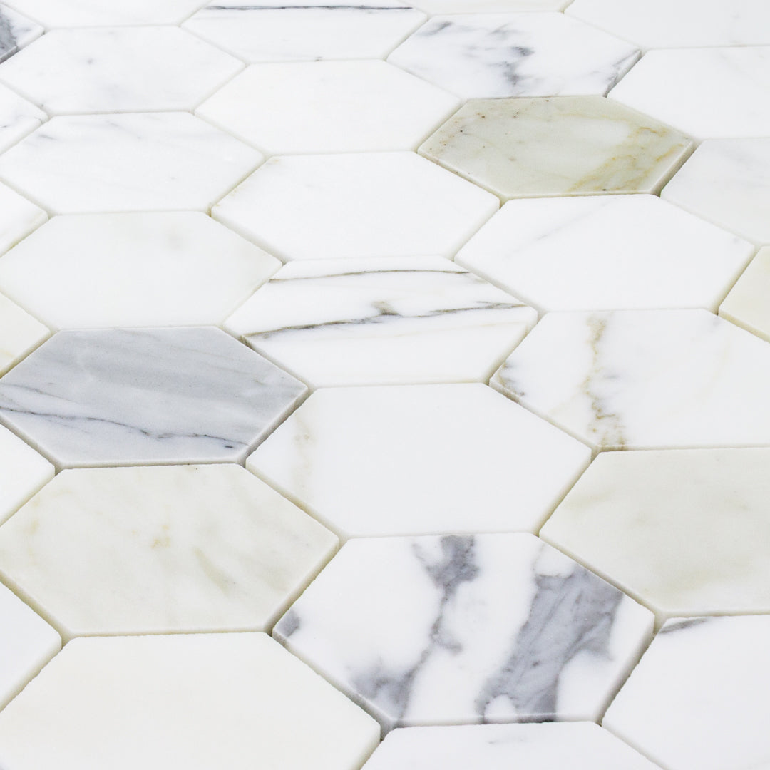 a close up of a sheet of matte calacatta 3" hexagon mosaic