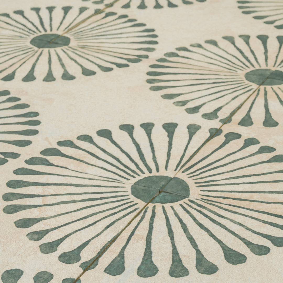 A close up angled view of the Miramar green 8x8 sun burst pattern tile highlighting the handpainted look. 