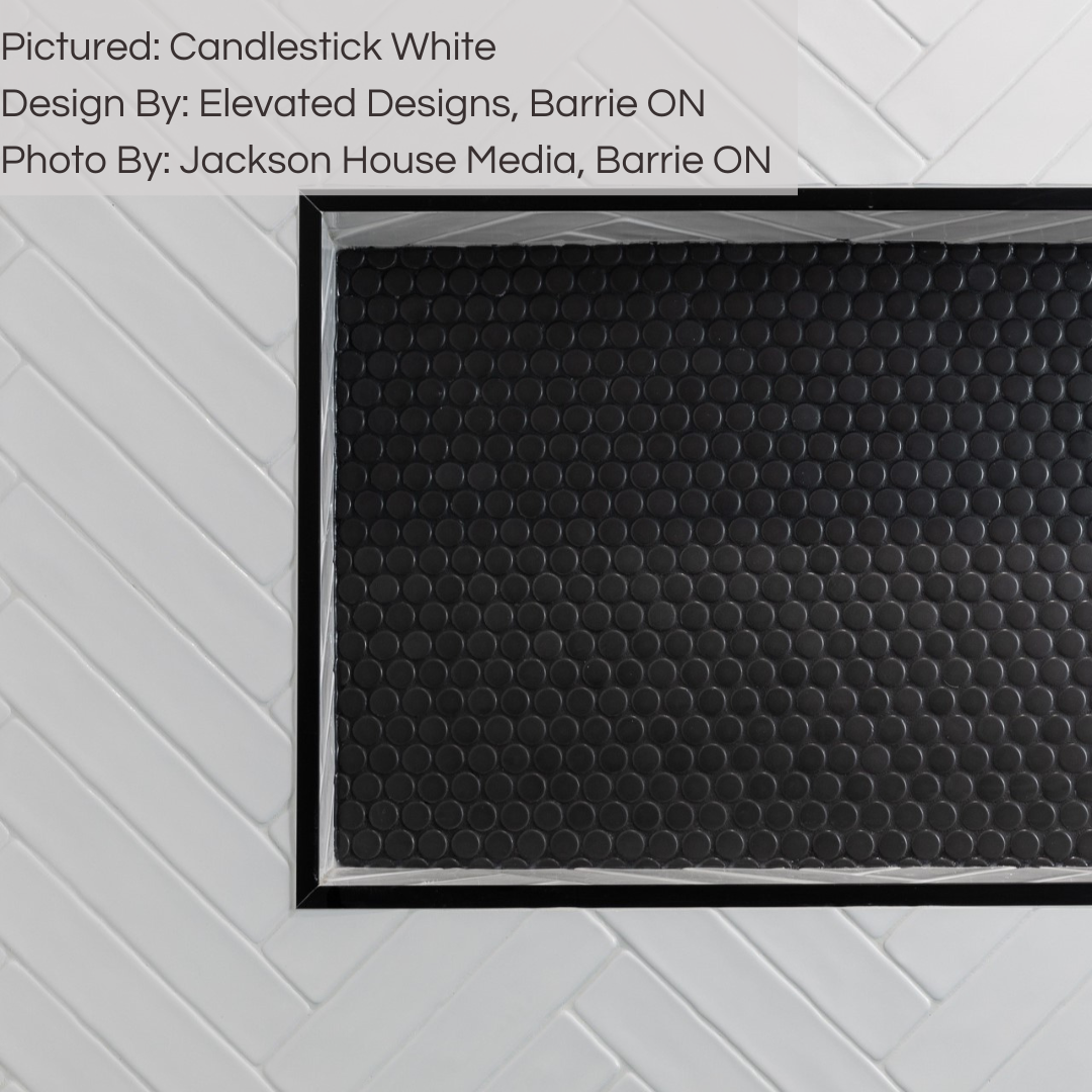 A clsoe up of a black and white shower using 2x10 candlestick white glossy in a chevron pattern. 