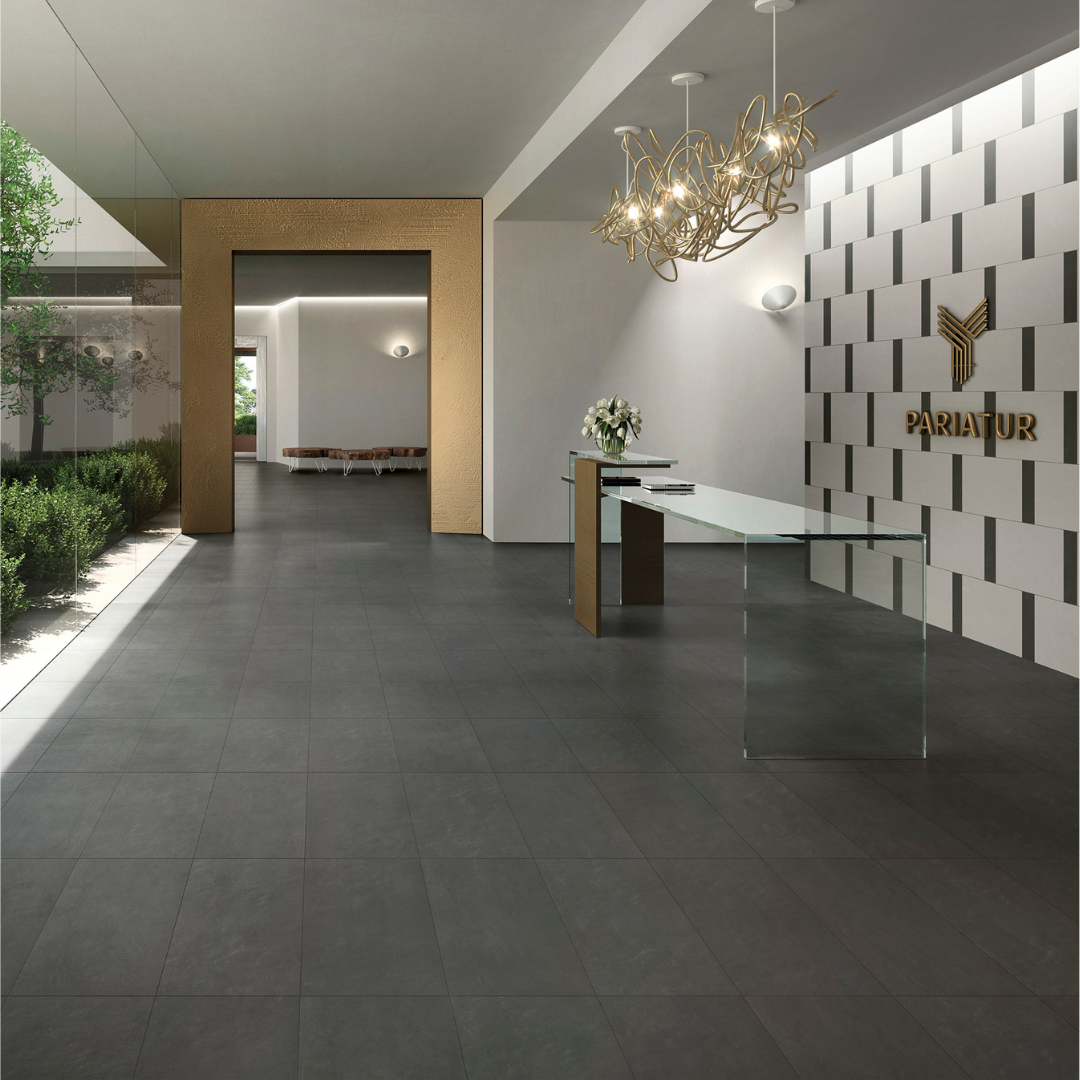In a commercial board room or solarium there are 12x24 black tiles on the floor. As a backdrop of the branding on the wall, there is a tile pattern featuring white 12x24 and black 4x12 tiles. 