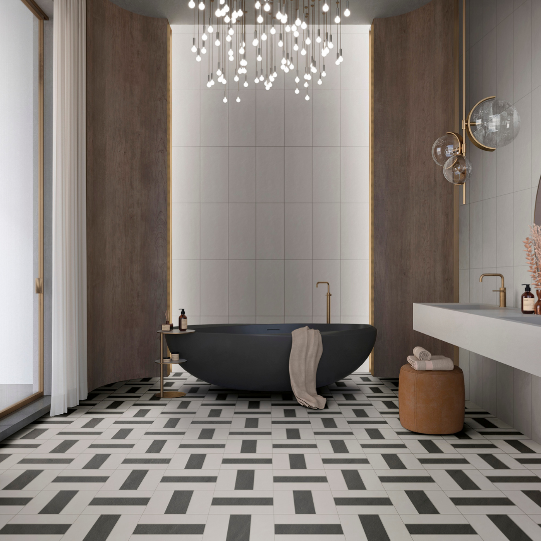A modern oasis bathroom featuring a black stone tub, gold and wood accents and a customized tile pattern on the floor using 4x12 white and 4x12 black tiles. There is also white 12x24 tiles in a vertical stack on the wall behind the tub and bathroom vanity. 