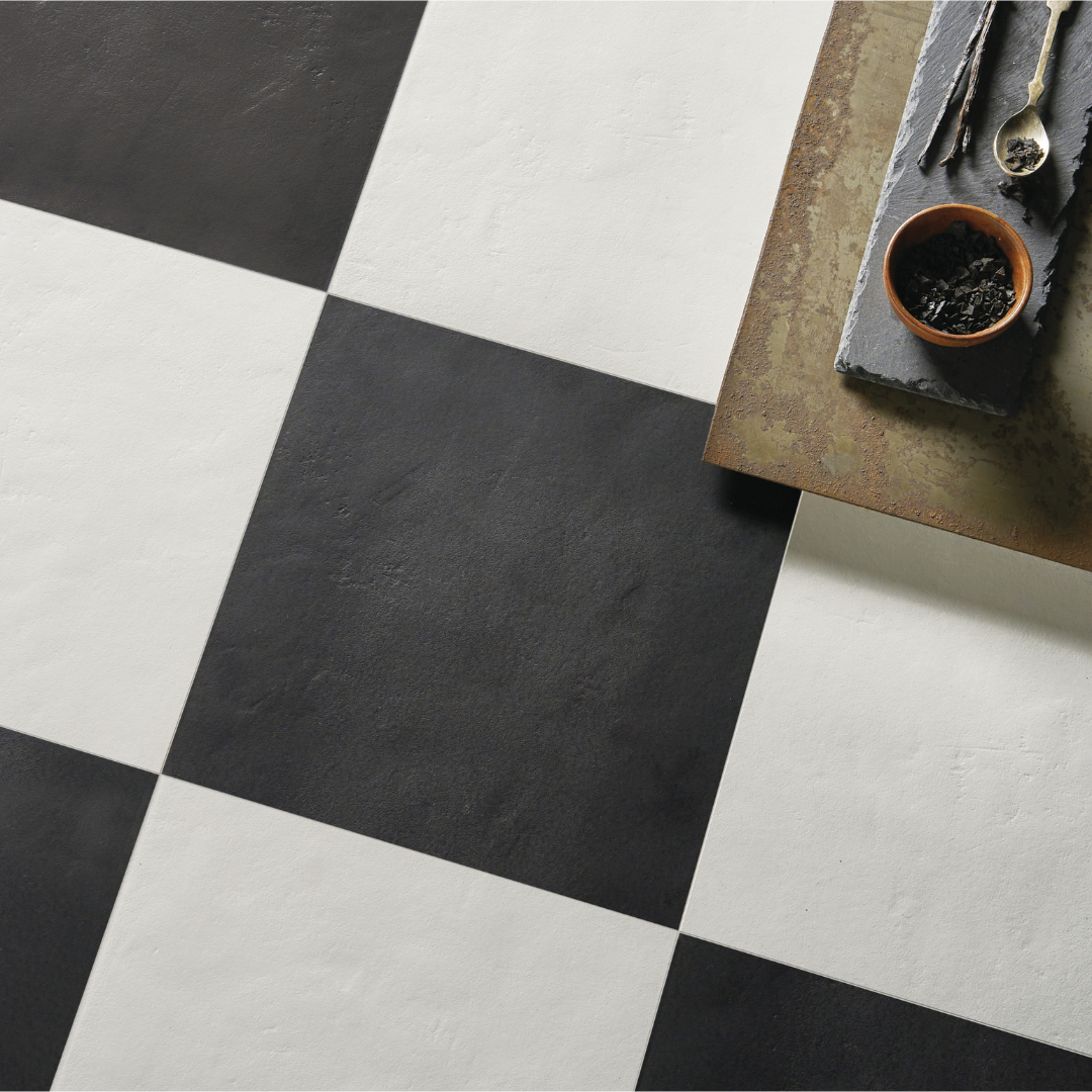 An ariel view of a checkerboard floor tile installation. Checkmate White 12x12 and Checkmate Black 12x12, these two tiles feature a slight stone look, with subtle texture and a matte finish. 