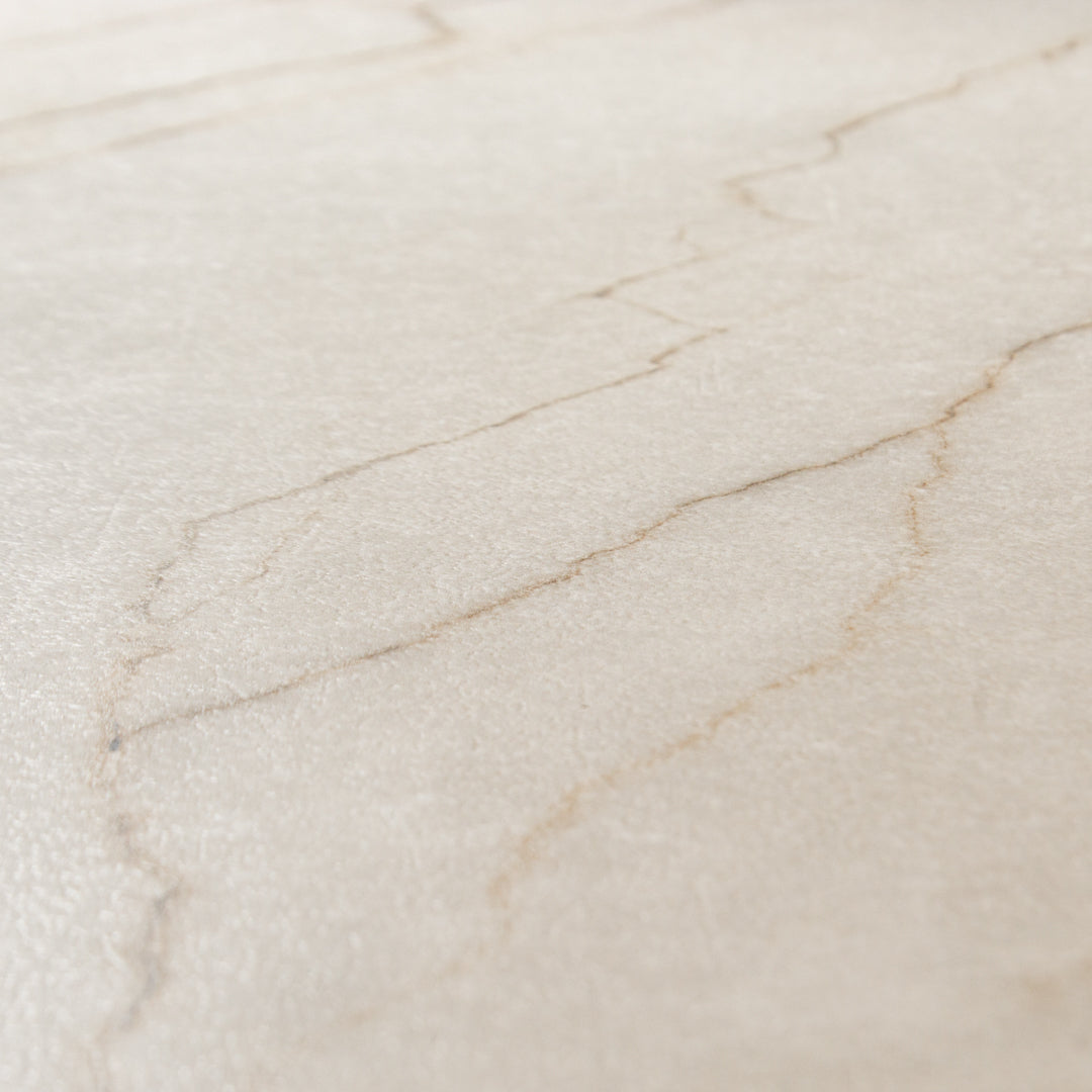 Angled  close up of a single 24x48 marble look cream warm white avorio tile with thin gold veining and matte finish