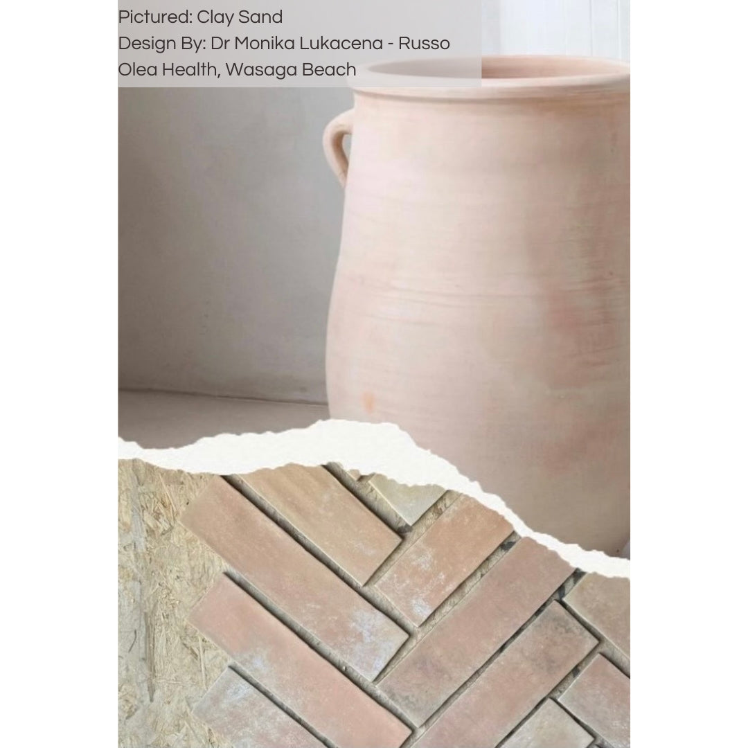 Samples of 11x2.75 brick clay sand beige stone look tile with a natural looking edge laid out in a herringbone display being compared to a light beige terracotta pot. 