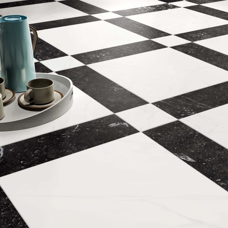 Angled close up view of a black and white geometric pattern floor tile. There is white 16x16 stone look tiles surrounded by Black 5x16 stone look tiles with 5x5 white stone look tiles at the corners. 