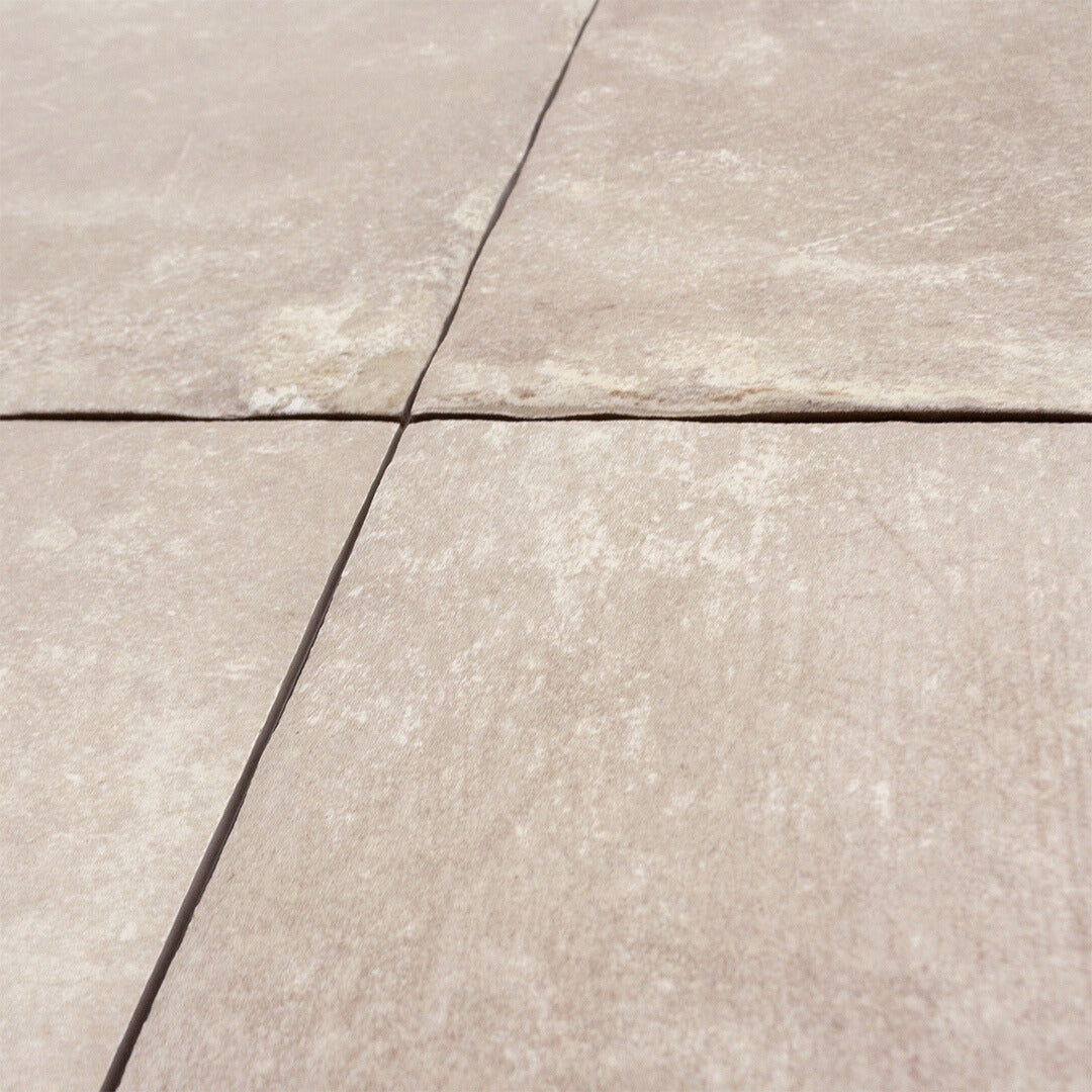 Angled close up to show off the tumbled texture of our cottage cream porcelain paver look tiles. 