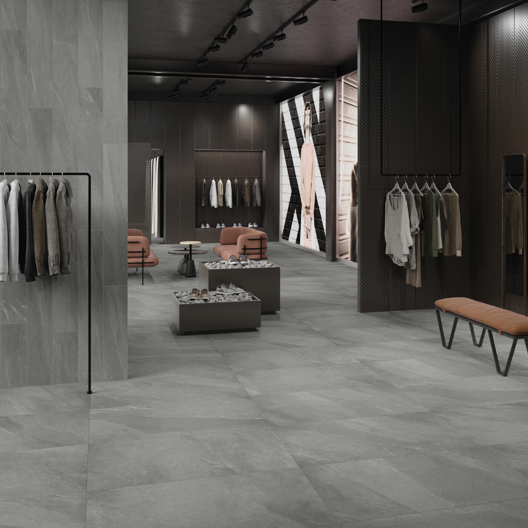 An urban sophisticated retail setting with dark grey limestone look tiles on the floors in 24x48 and 4x12 on the walls. There are ebony wood, black metal and cognac accents. 