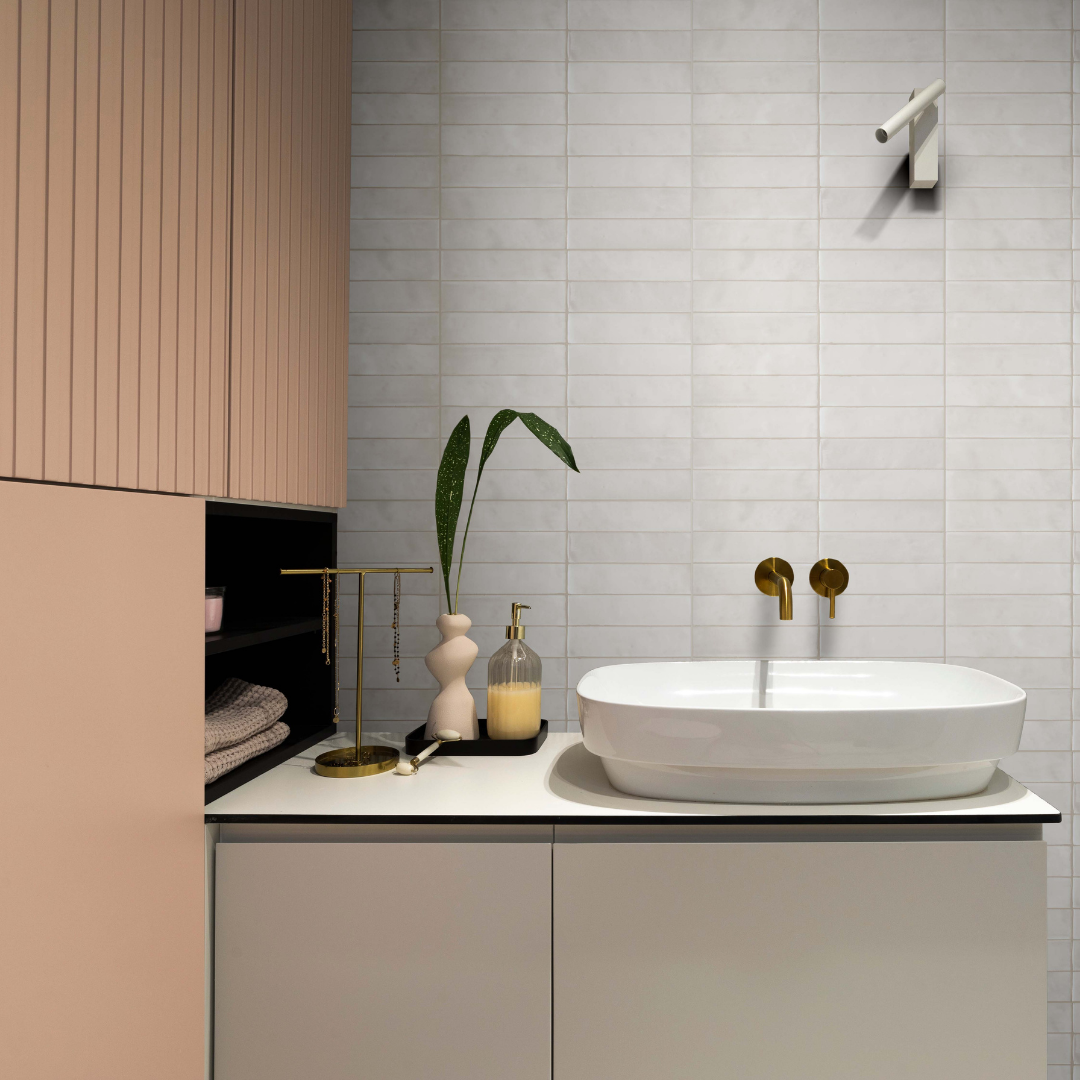 A modern installation of white matte 2x9 subway tiles on a bathroom vanity backsplash laid out in a horizontal stack pattern. The tile features a slight colour variation and a handmade look. 