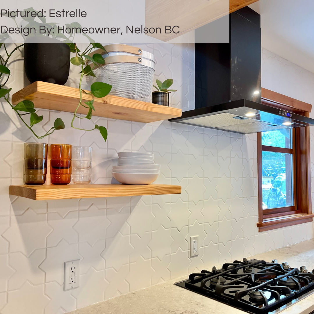 A close up of a kitchen backsplash with white counters, wood open shelves and estrelle white star and x cross shaped pattern tiles. 