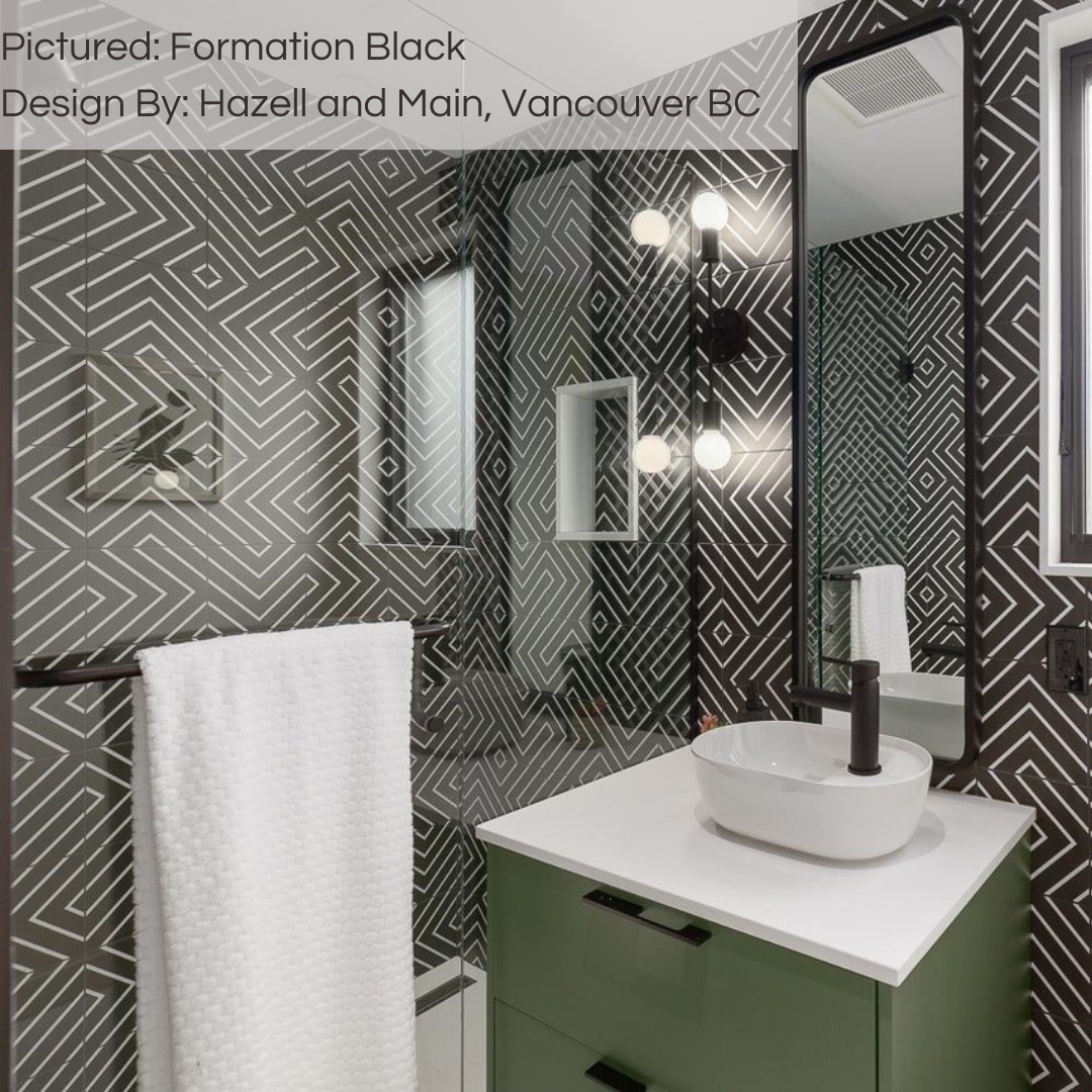 A modern black bathroom with a green vanity. the tiles are black formation geometric pattern 8x8 tiles creating a funky eclectic vibe. 