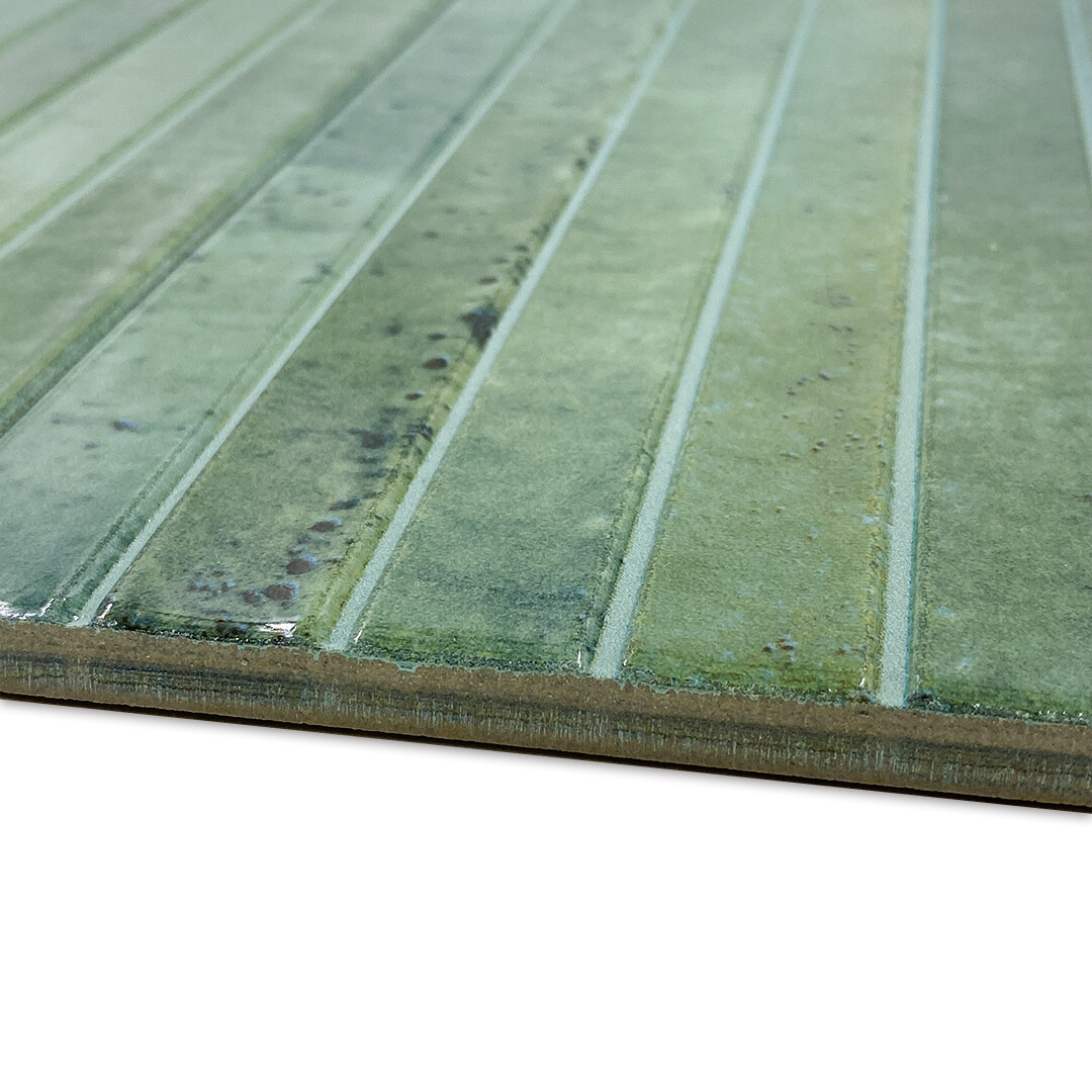 Angled close up of the edge of a single 5x10 panel tile in glossy green, the tile has a 3D linear faux grout line kitkat look and colour variation. 