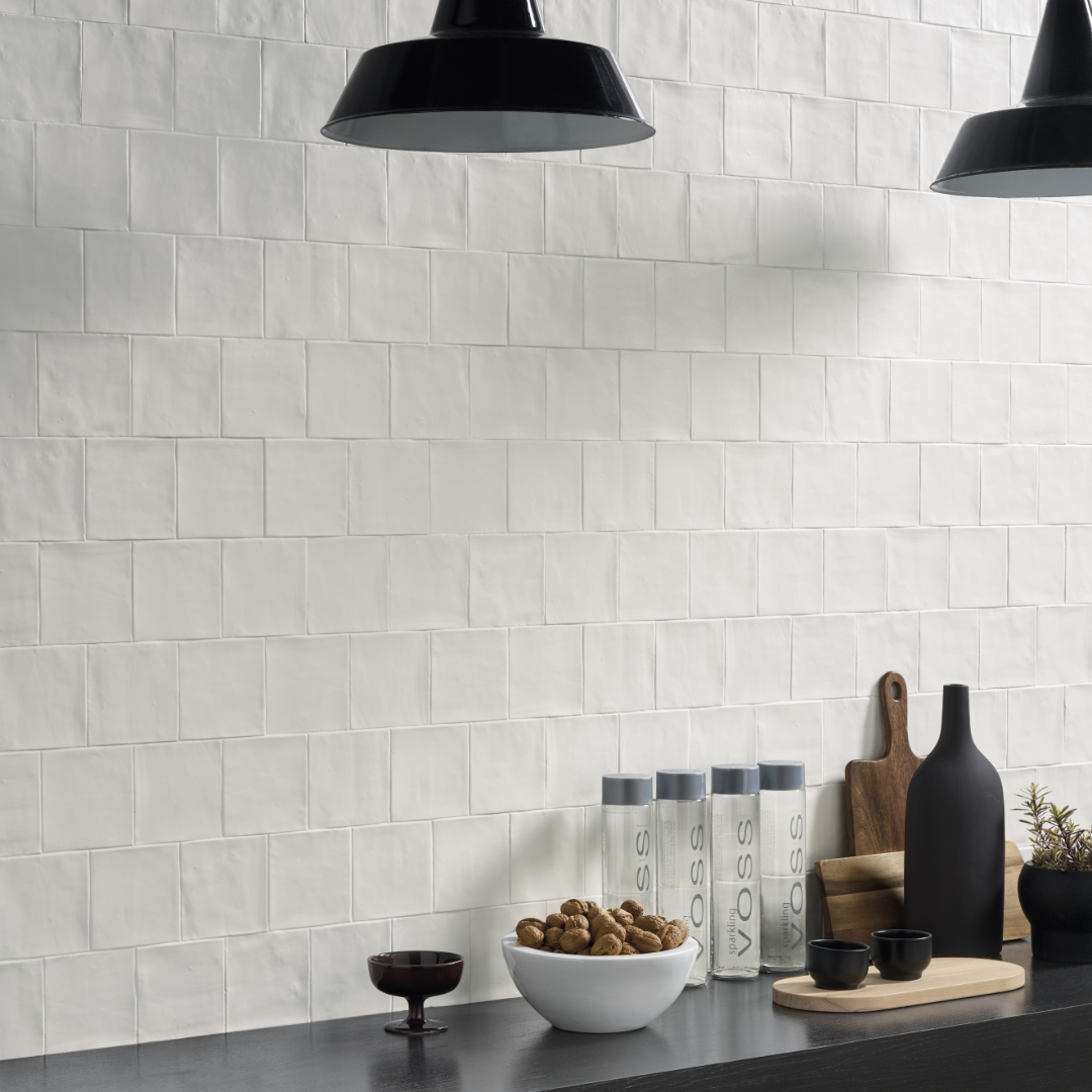 A minimalist bar area with black accents, the backsplash wall features textured matte white 5x5 tiles. 