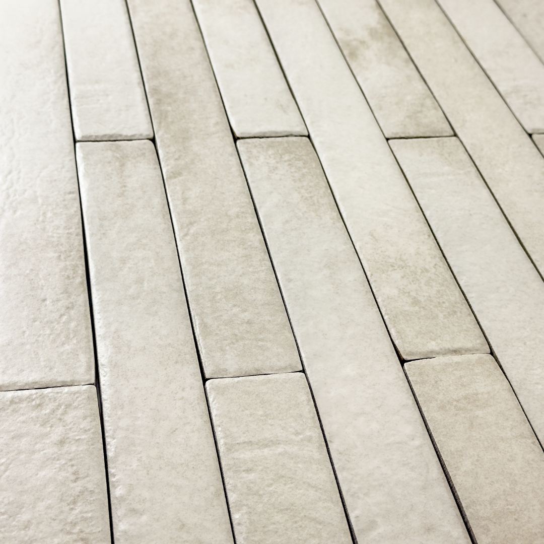 Angled view of off white  2x18 brick look tiles in a vertical brick pattern. Showing the texture, colour variance and finish of the tiles.