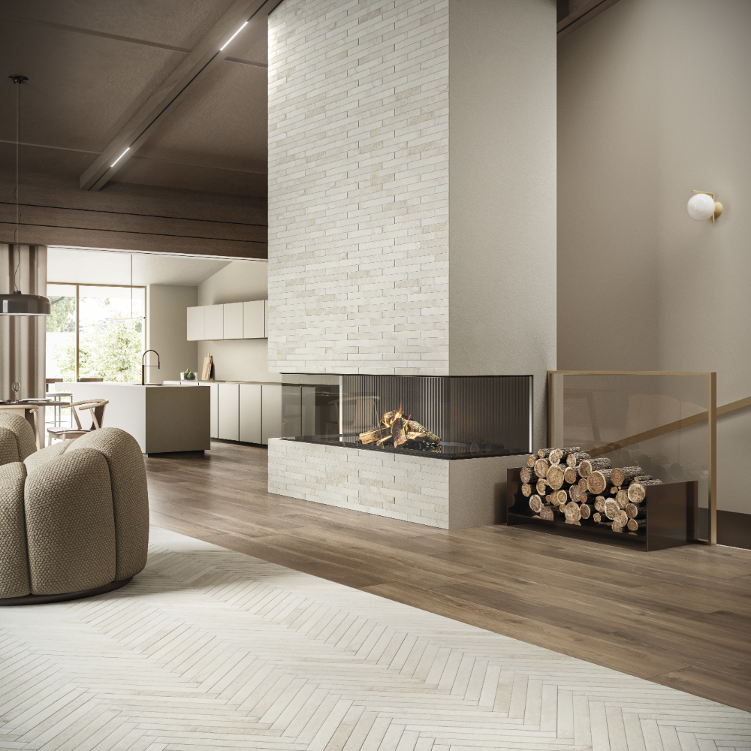 A modern living room with warm accents and a fireplace. The face of fireplace is offwhite 2x18 brick look tiles in a horizontal brick pattern. There is a section of flooring in the living space that also has the same tile but laid out in a herringbone pattern. Showing the texture, colour variance and finish of the tiles. 