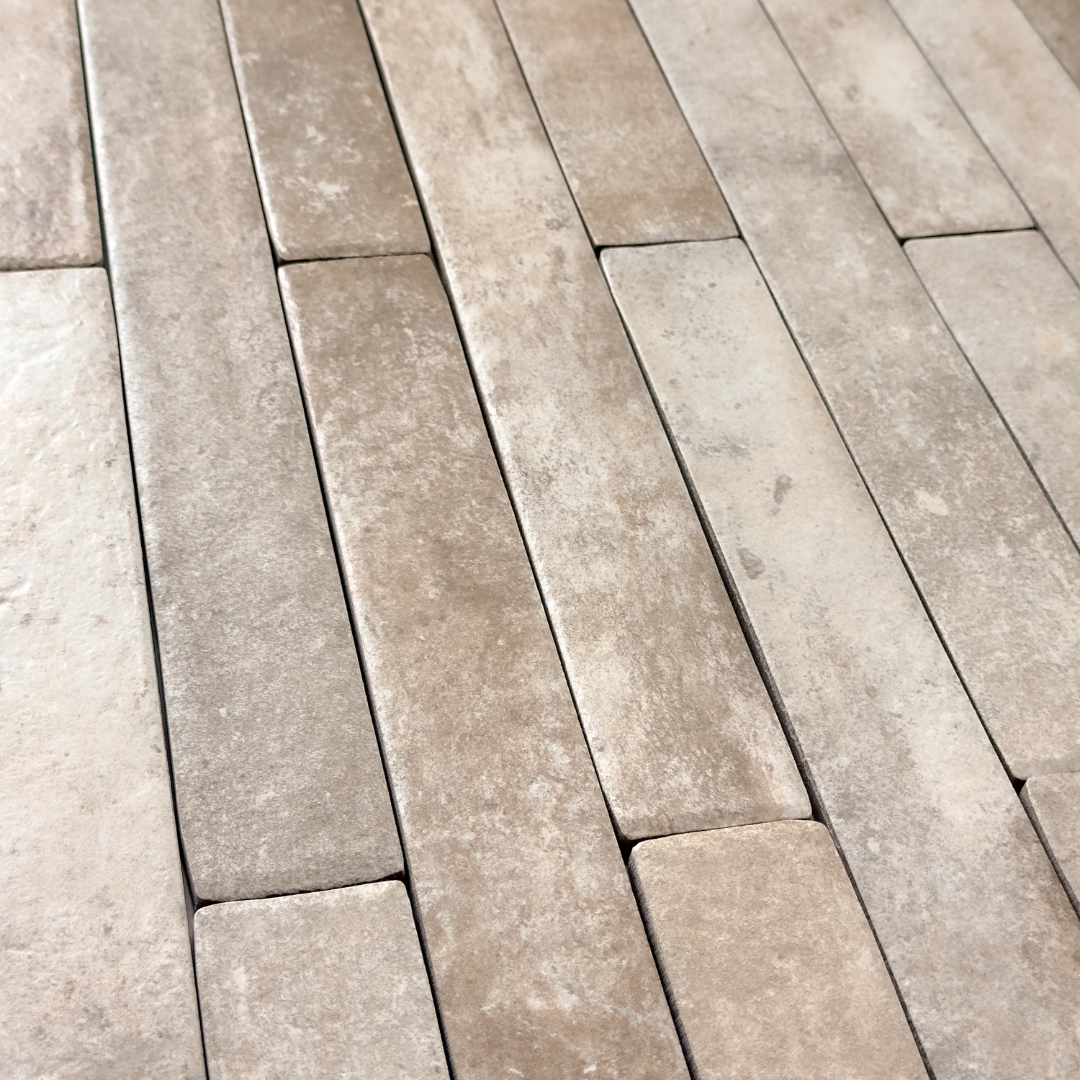 Angled view of beige  2x18 brick look tiles in a vertical brick pattern. Showing the texture, colour variance and finish of the tiles.