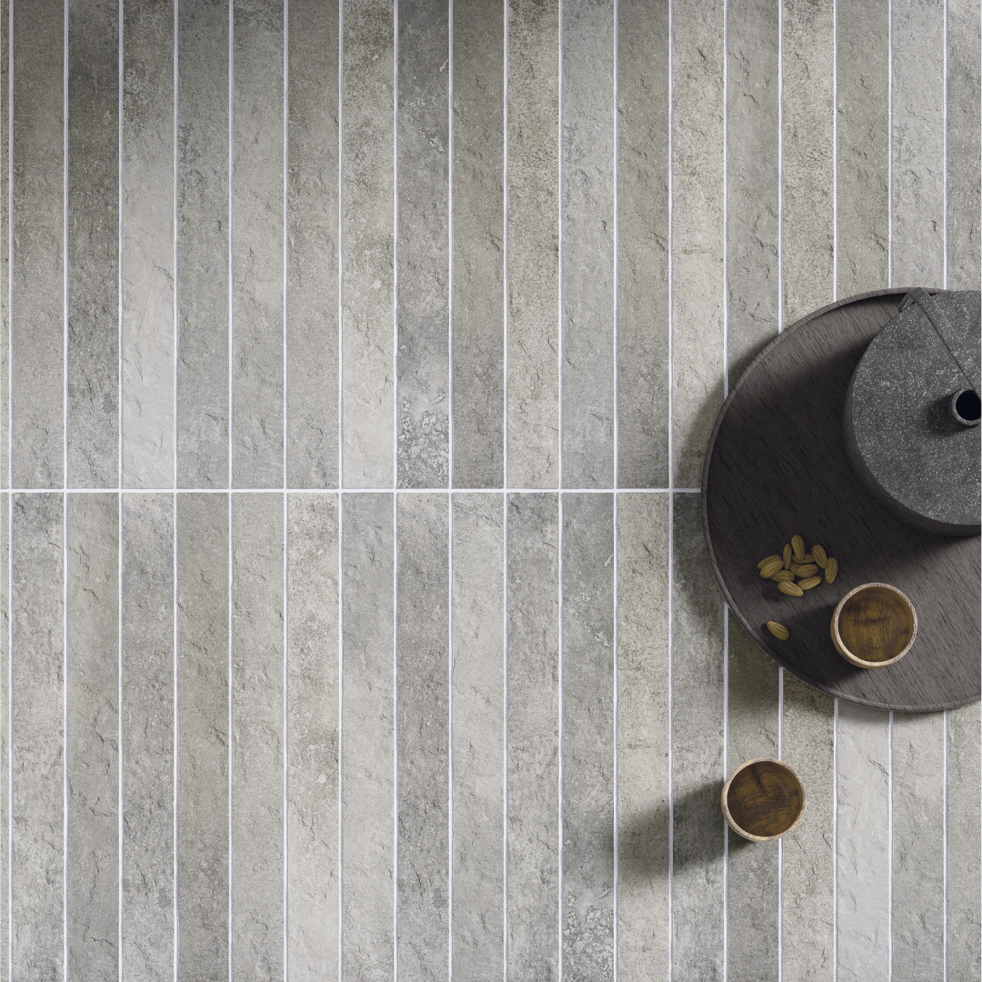 A close up of a tiled table surface. The tiles are 2x18 grey brick look tiles with colour variation, light texture and installed in a modern stacked pattern. 