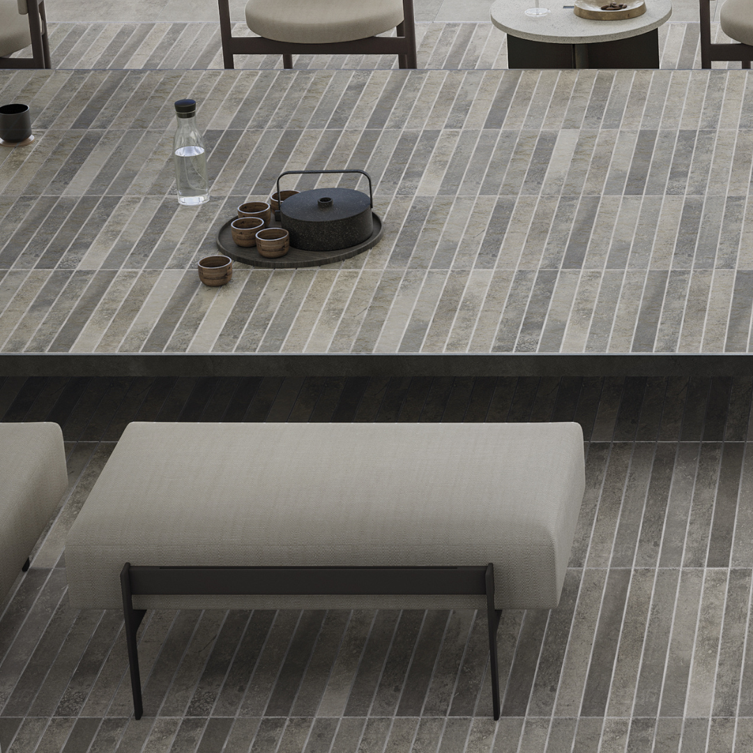 An exterior tiled patio with tiled patio bench table. The tile is 2x18 grey brick look tiles with colour variation. 