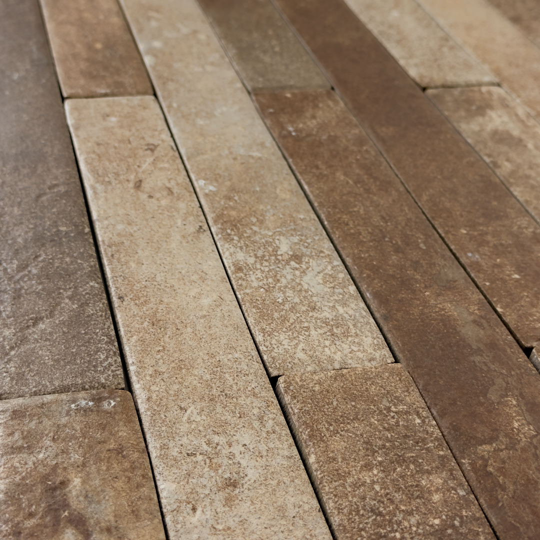 Angled close up view of terracotta brown 2x18 brick look tiles laid in a vertical brick pattern. Showing colour variance, texture and the finish. 