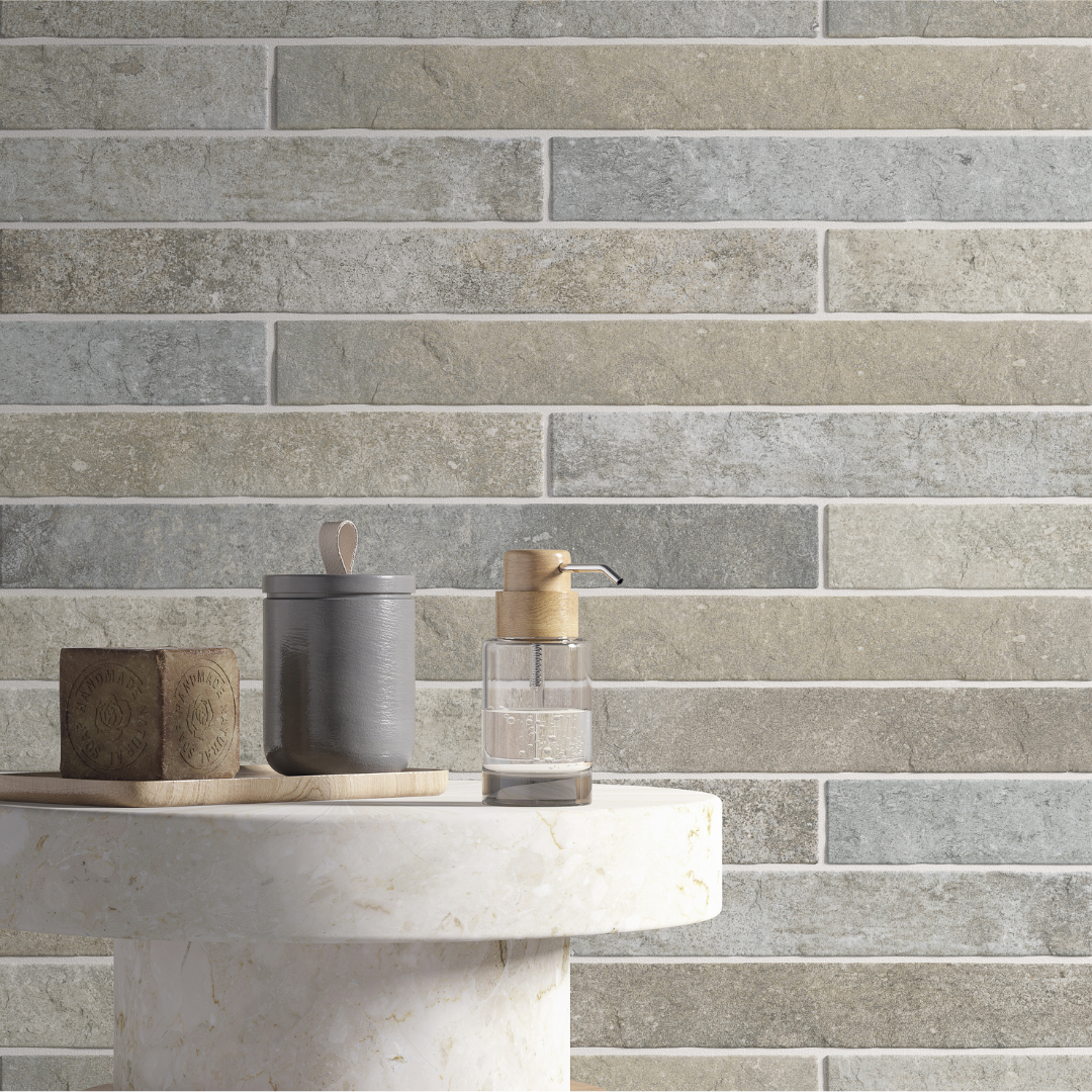 A close up view of a wall or backsplash, the tile is greige 2x18 brick look tiles in a horizontal brick pattern with some colour variation and texture. 