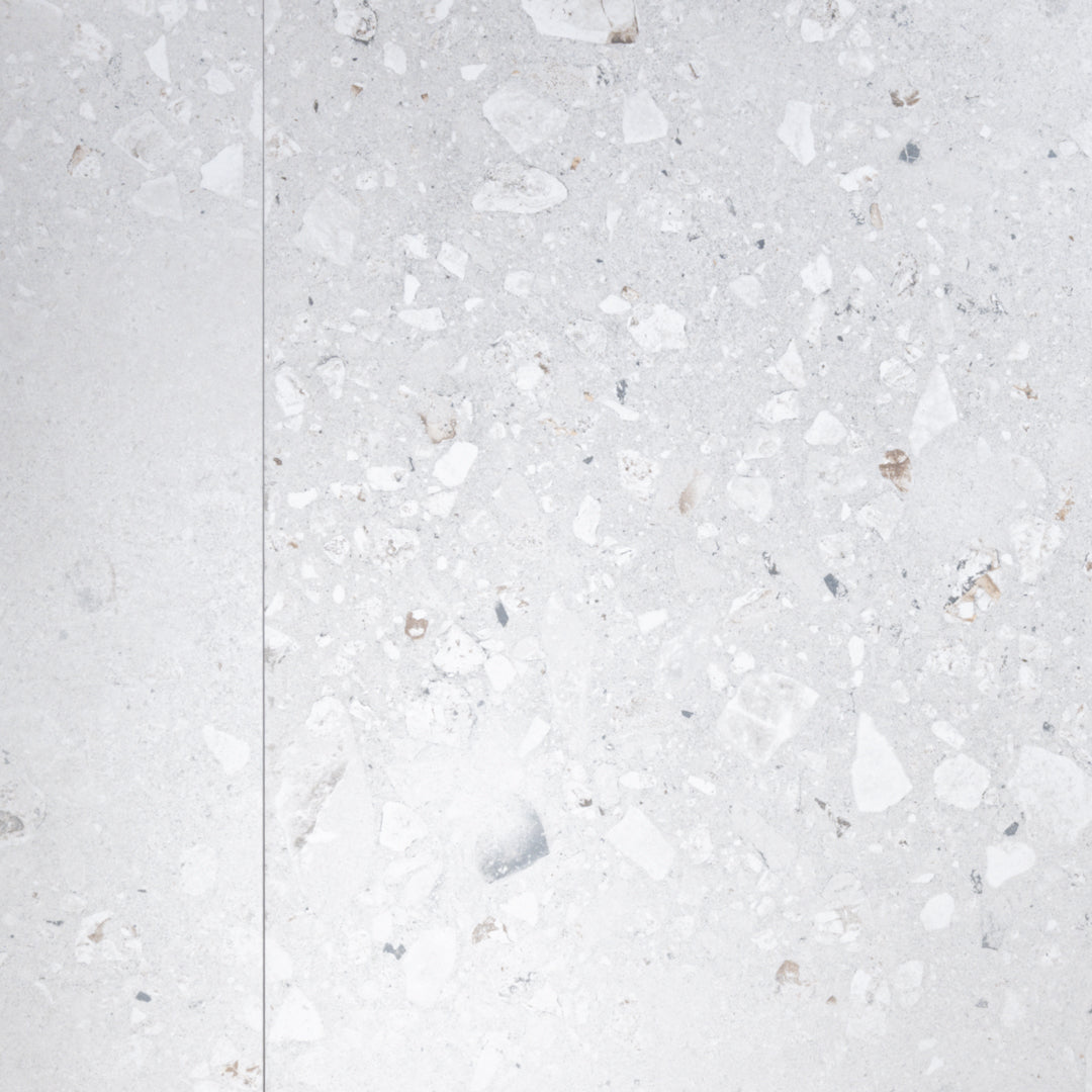A side by side of two 36x36 cement terrazzo look tiles called oasis pearl they have a light grey stone base with light and grey flecks. 