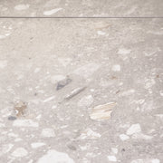 a close up of two 36x36 porcelain terrazzo cement look tiles in a warm grey beige base with light and dark flecks.