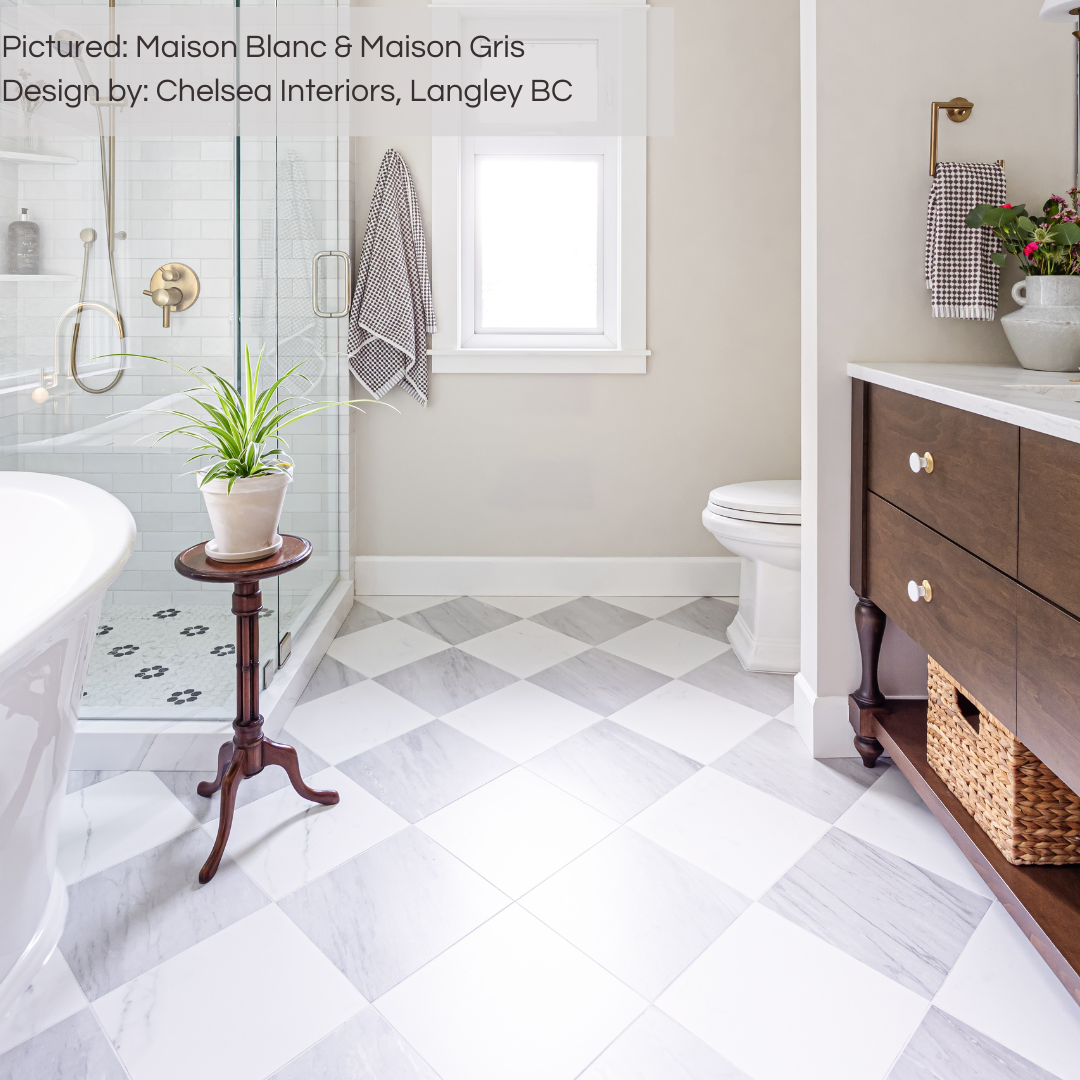 A sophisticated ensuite bathroom with marble look grey and white porcelain tiles on the floor laid out in a diamond checker pattern. there are rich wood accents and white plumbing fixtures. 