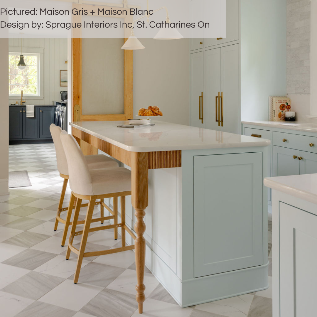 A classic transitional kitchen with pale seafoam blue cabinets, oak wood accents, gold hardware and our grey and white maison marble look checker tiles installed on the floor. the flooring is also extended into the mudroom at a distance. 