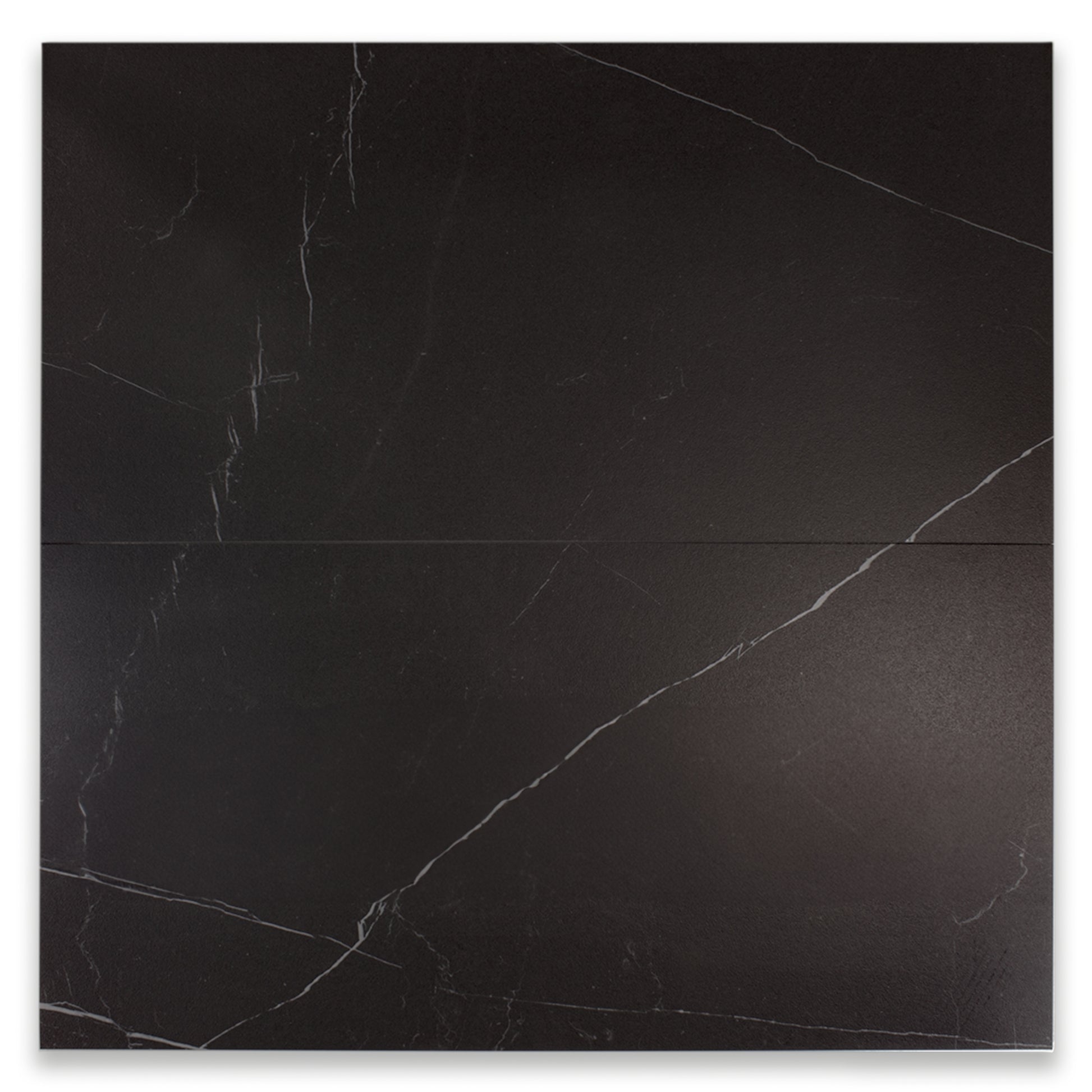 Ariel view of two large rectangular tiles in matte black marble look porcelain with white veining. 