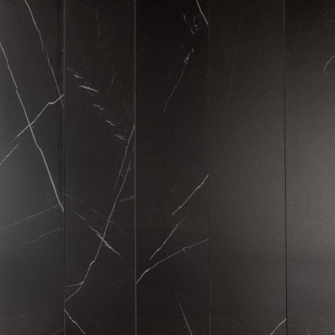Ariel view of a five 4 x 20 chevron tiles in matte black marble look porcelain with white veining. 