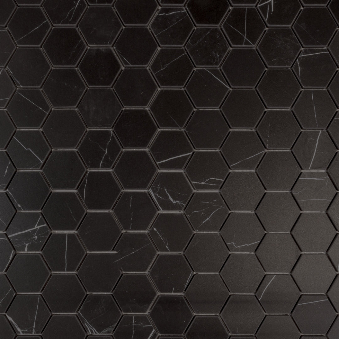 Ariel view of a matte soft black marble look porcelain hexagon mosaic tile to scale. 