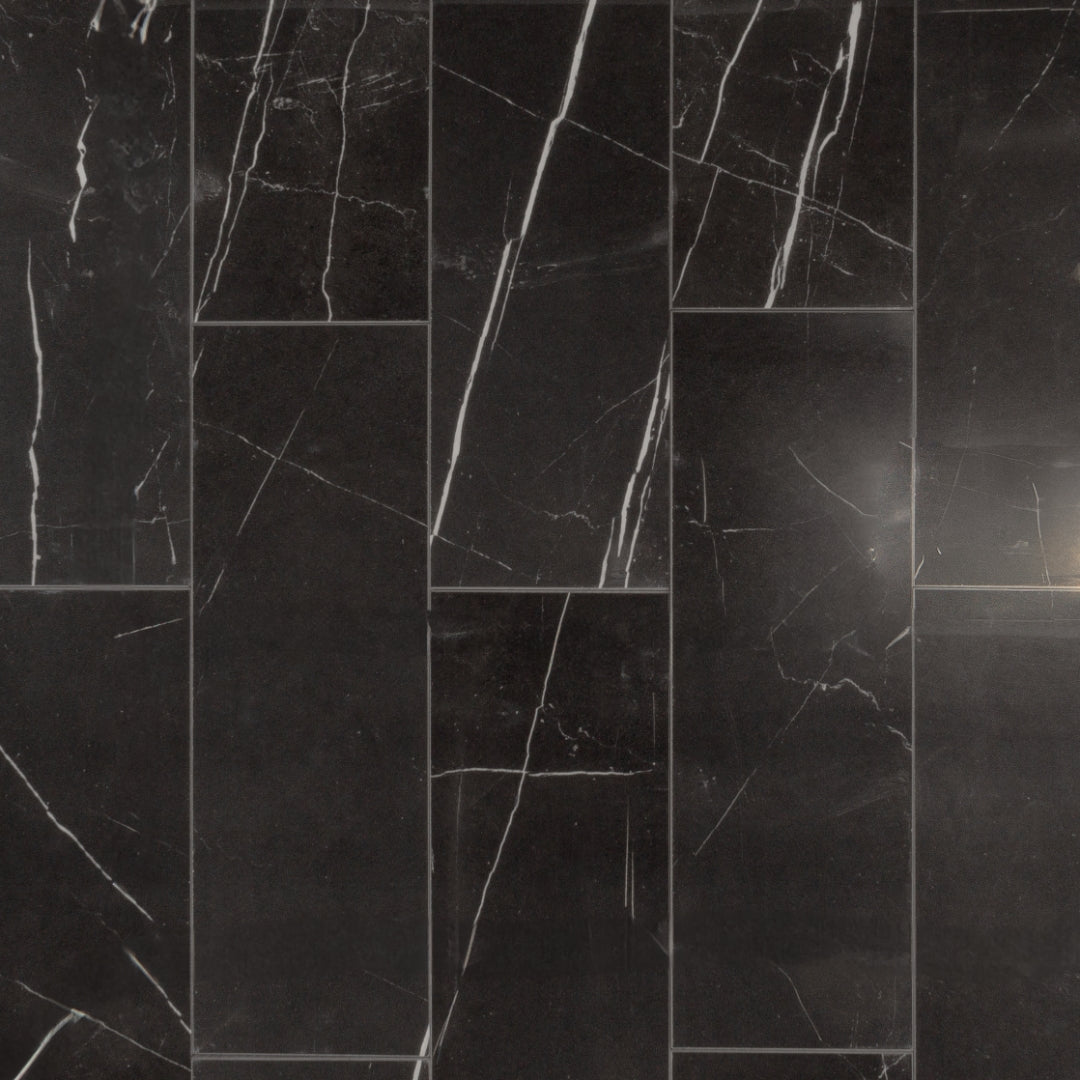 Ariel view of 4x12 tiles in polished glossy black marble look porcelain with white veining. They are laid out in a brick pattern. 