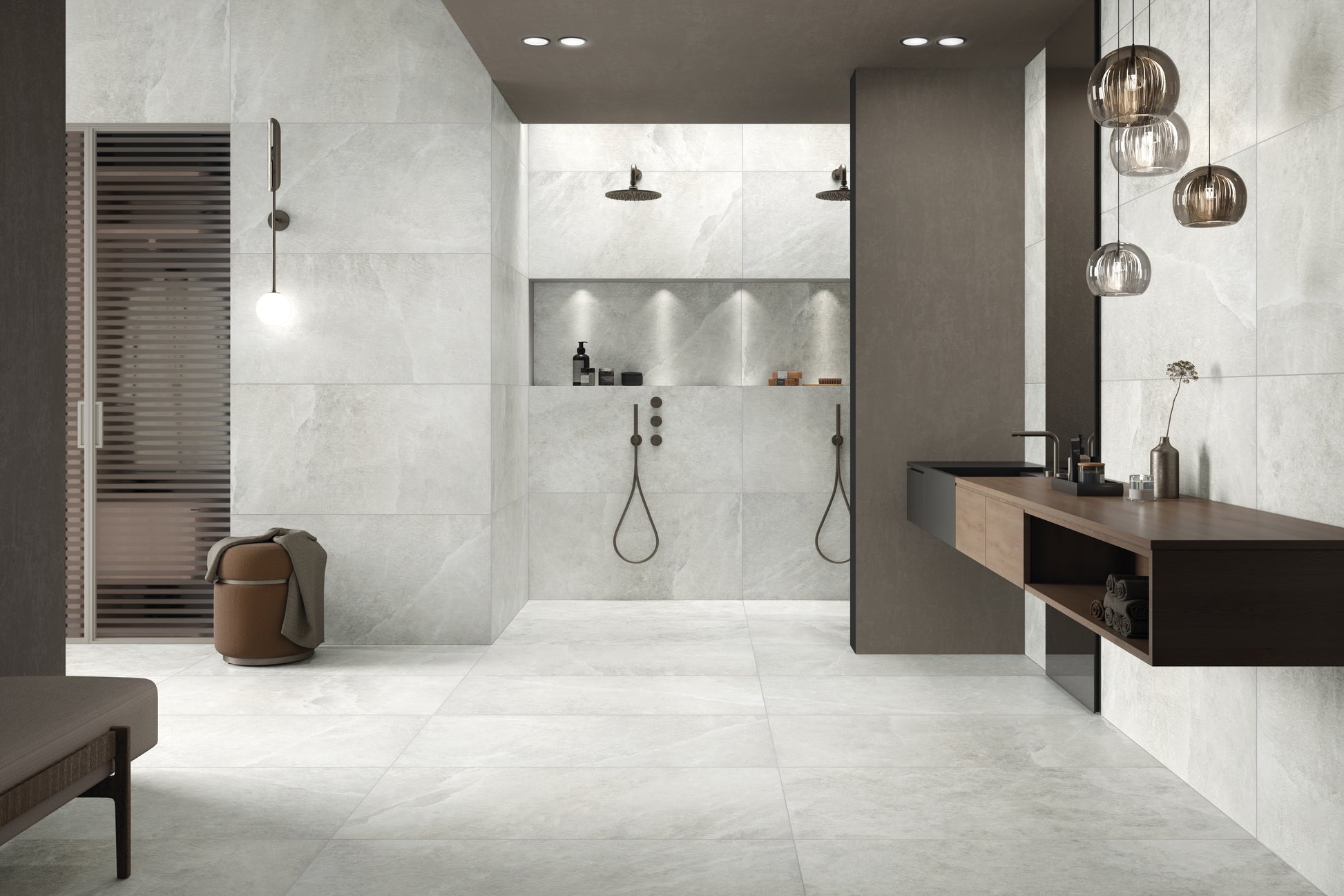A modern spa like bathroom with walk in showers and dark brown wood and accents. The floor and walls are tiled with a white stone look tile with some veining and soft natural vibe. 