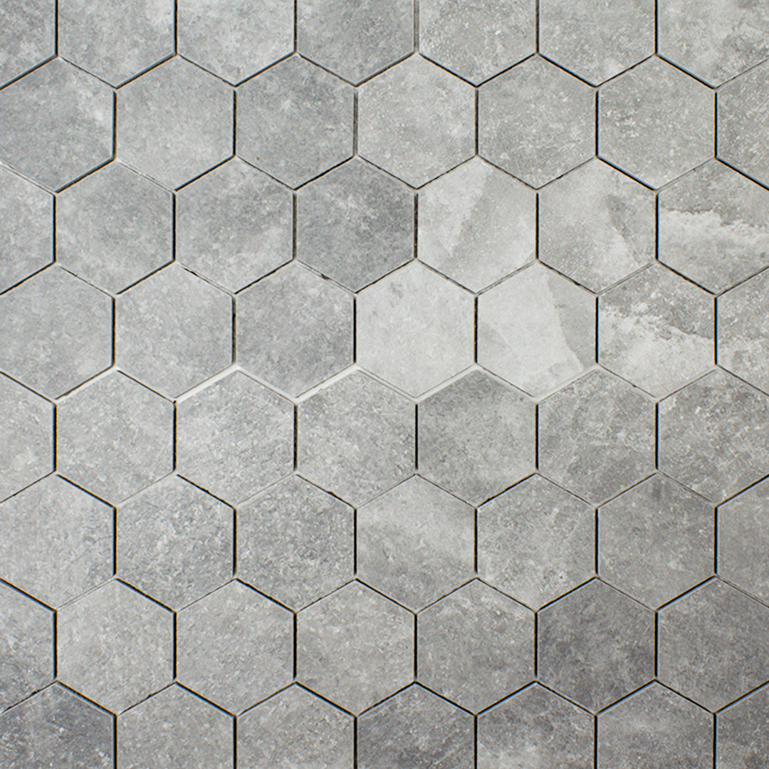Ariel view of 3" hexagon mosaic tiles in a dark grey stone look showing the texture and colour variation of concrete colours. 